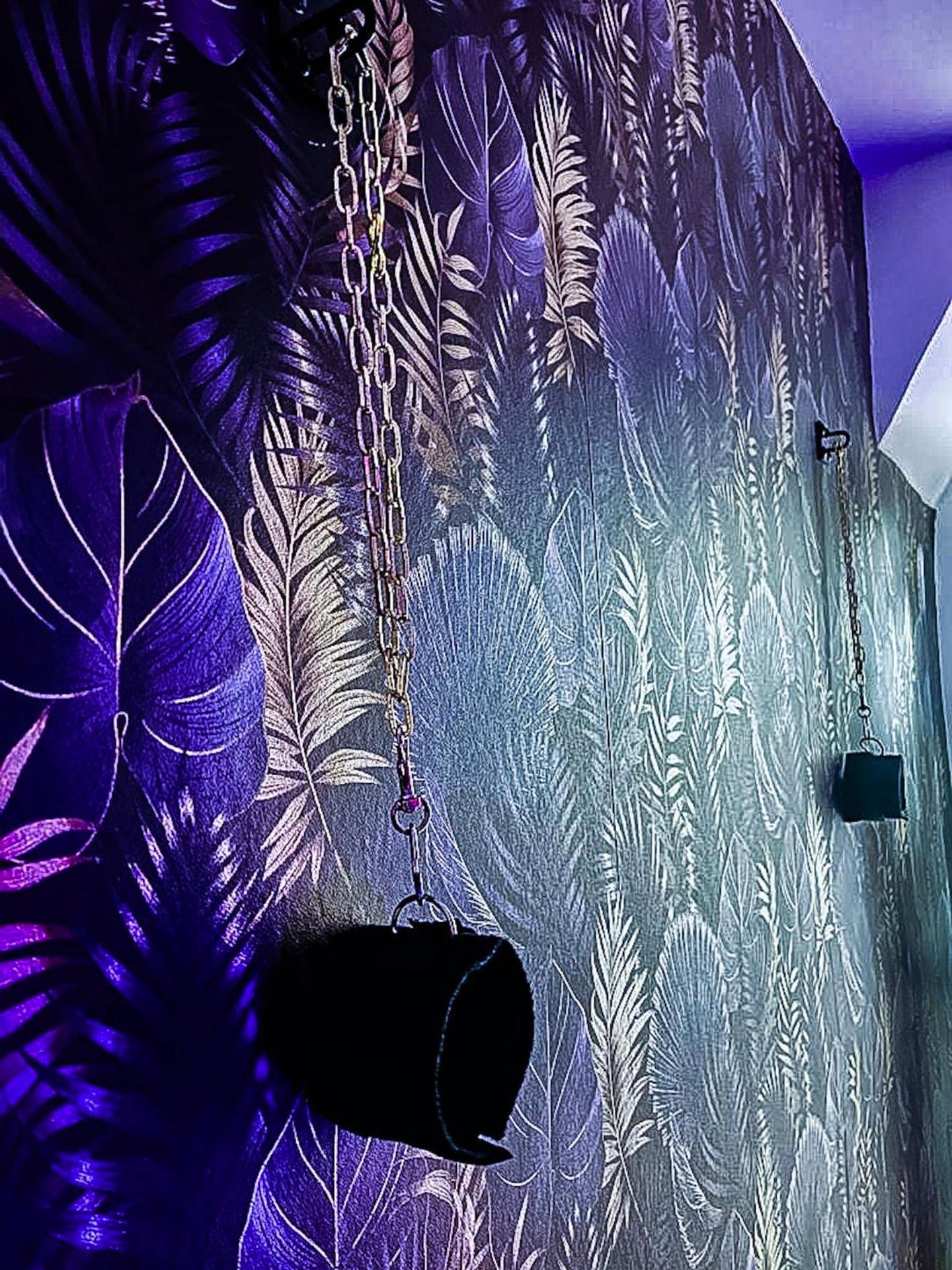 Détail de menottes sur mur végétal violet - Love Escape