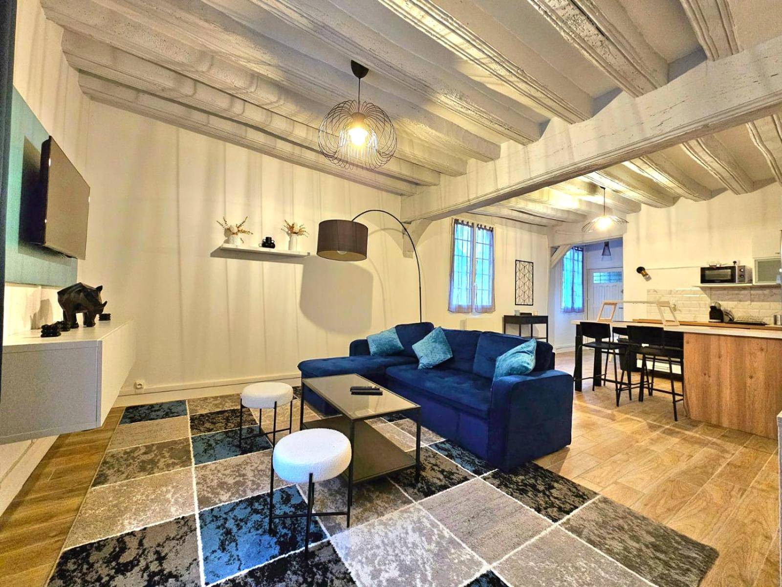 Salon moderne avec canapé bleu et poutres - Love Escape
