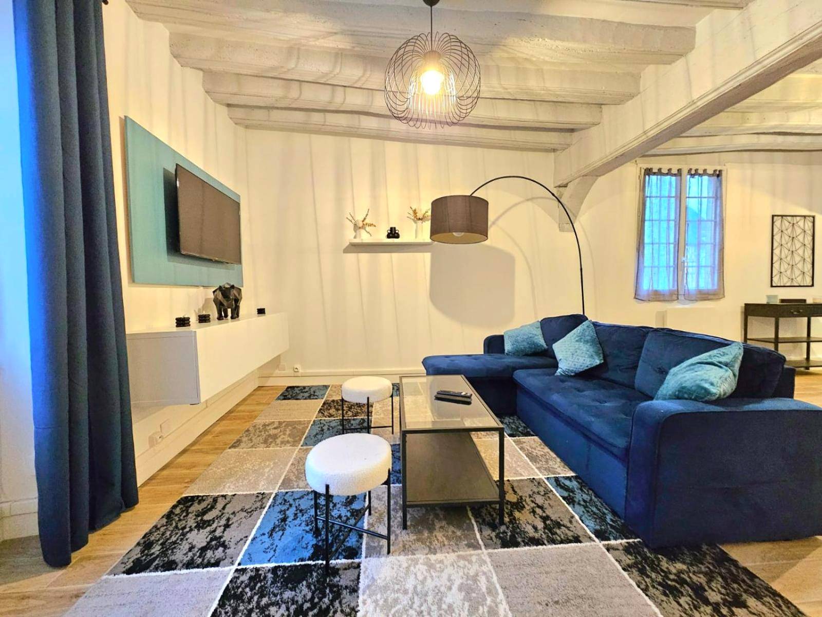 Espace séjour avec TV et tapis géométrique - Love Escape