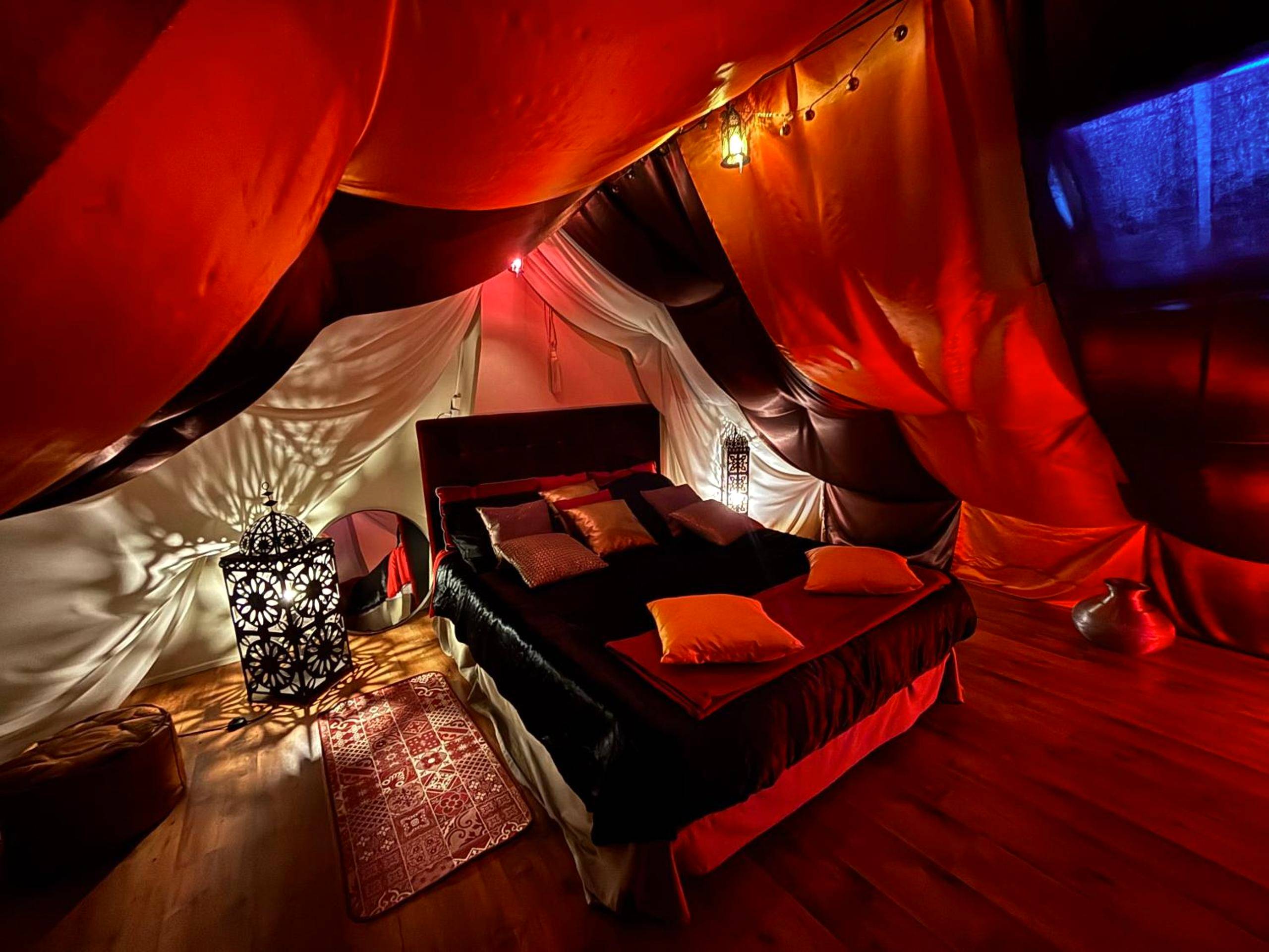 Lit double sous tentures rouges et blanches - Love room