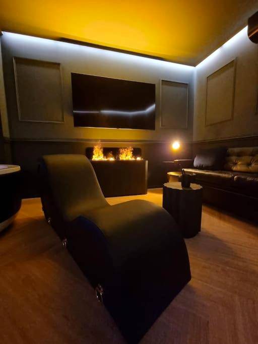 Fauteuil tantra face à la cheminée et TV - Love Room