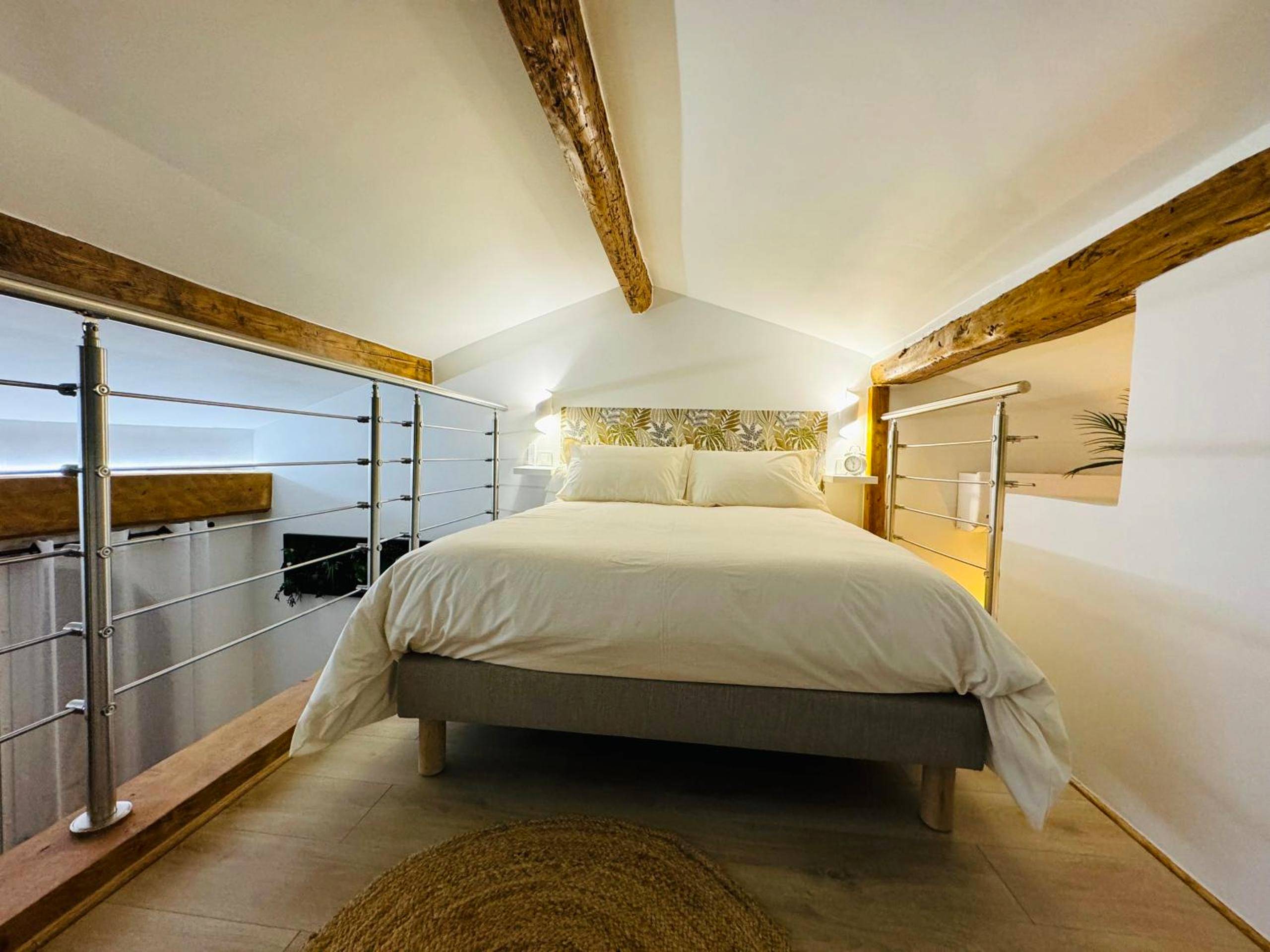 Lit double en mezzanine sous poutres apparentes - Love & Spa Fréjus
