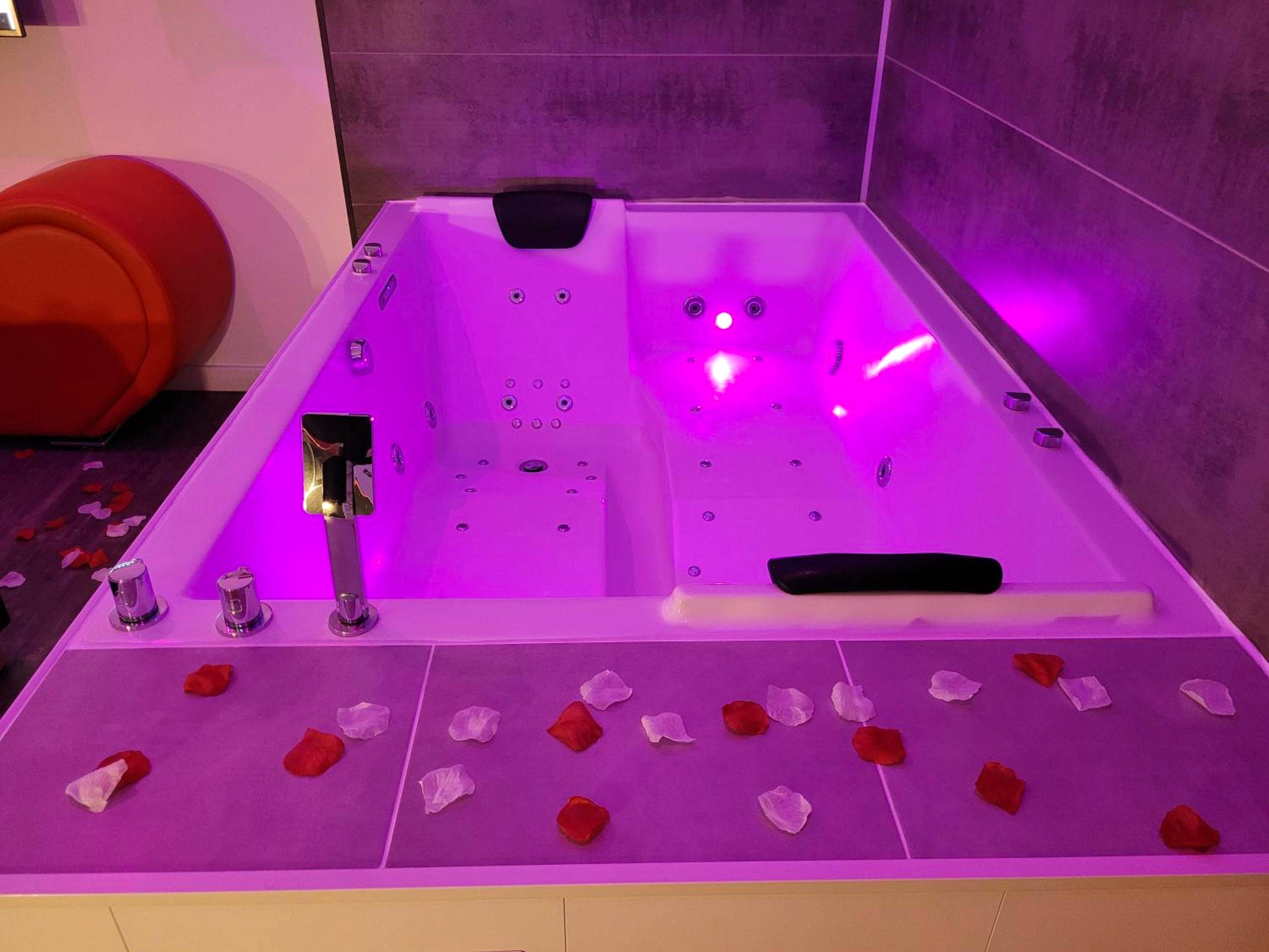 Jacuzzi privatif avec éclairage rose et pétales - Love & Spa