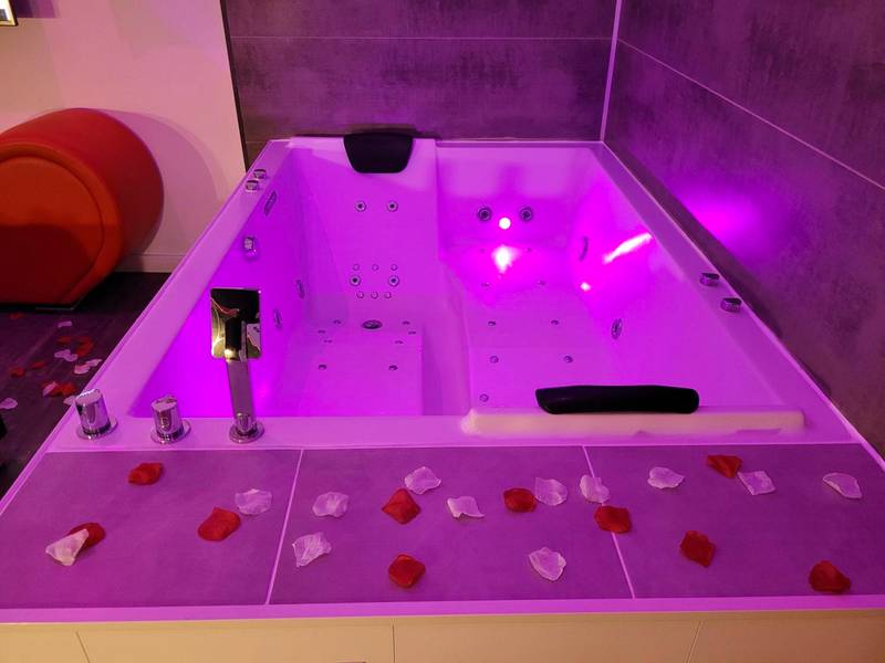 Jacuzzi privatif avec éclairage rose et pétales - Love & Spa