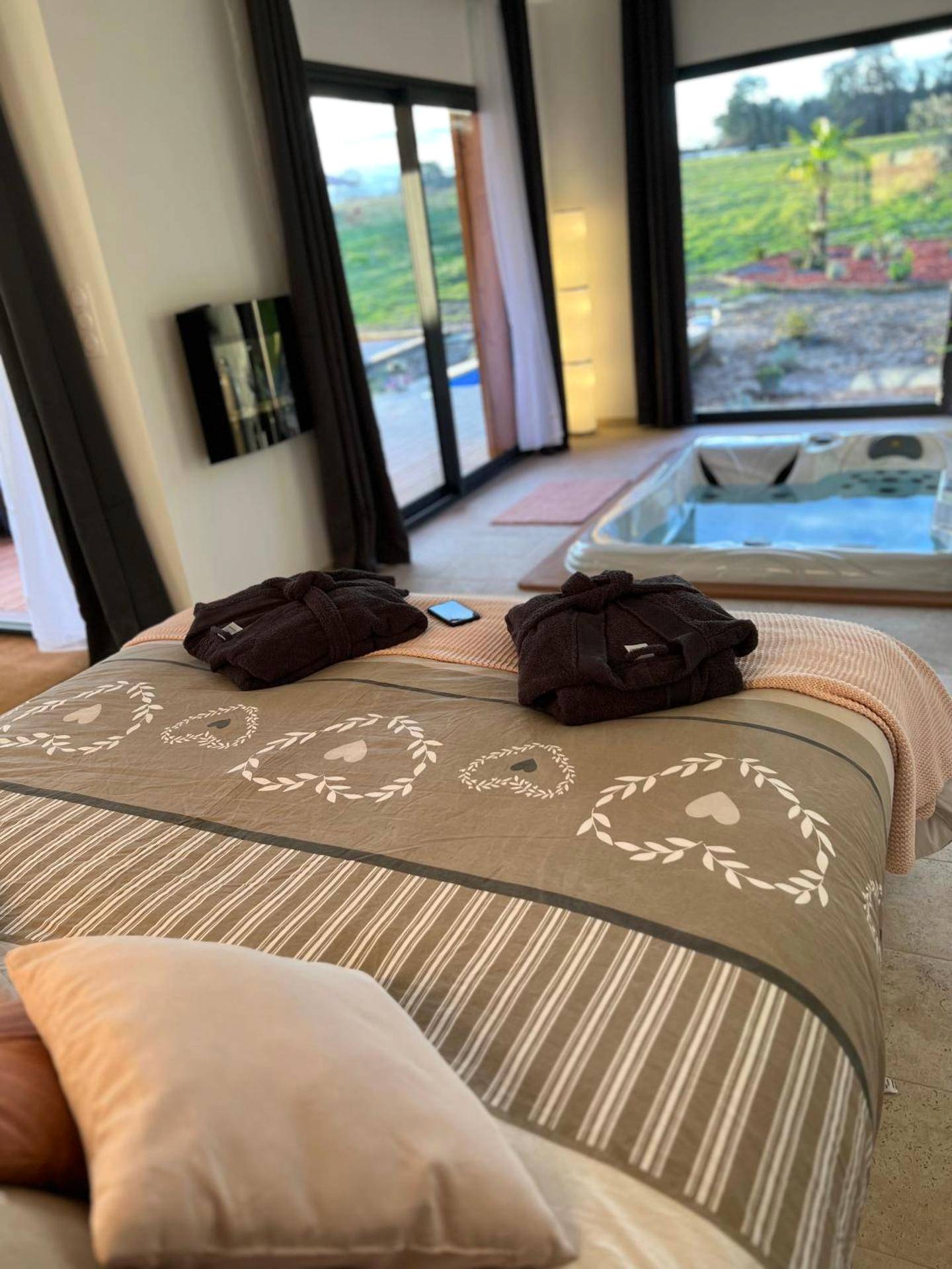 Lit avec peignoirs face au jacuzzi et jardin - LOVE AND BULLES