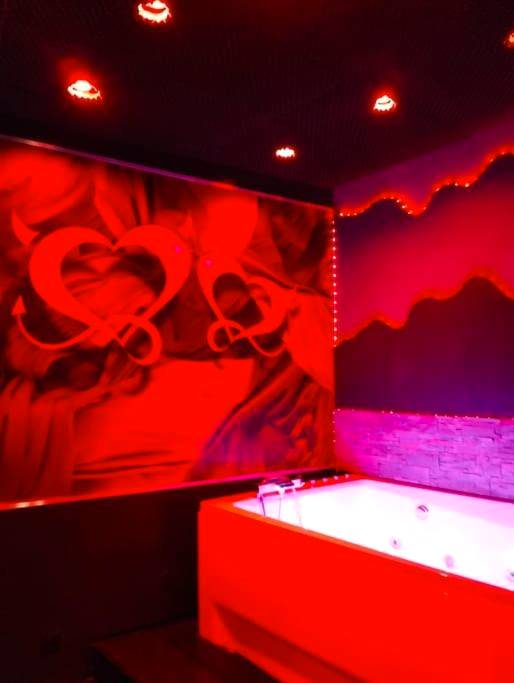 Baignoire balnéo sous un décor de cœurs rouges - Love Room Toulon - la lovecoquine, chez loveroomtoulon , parking et...