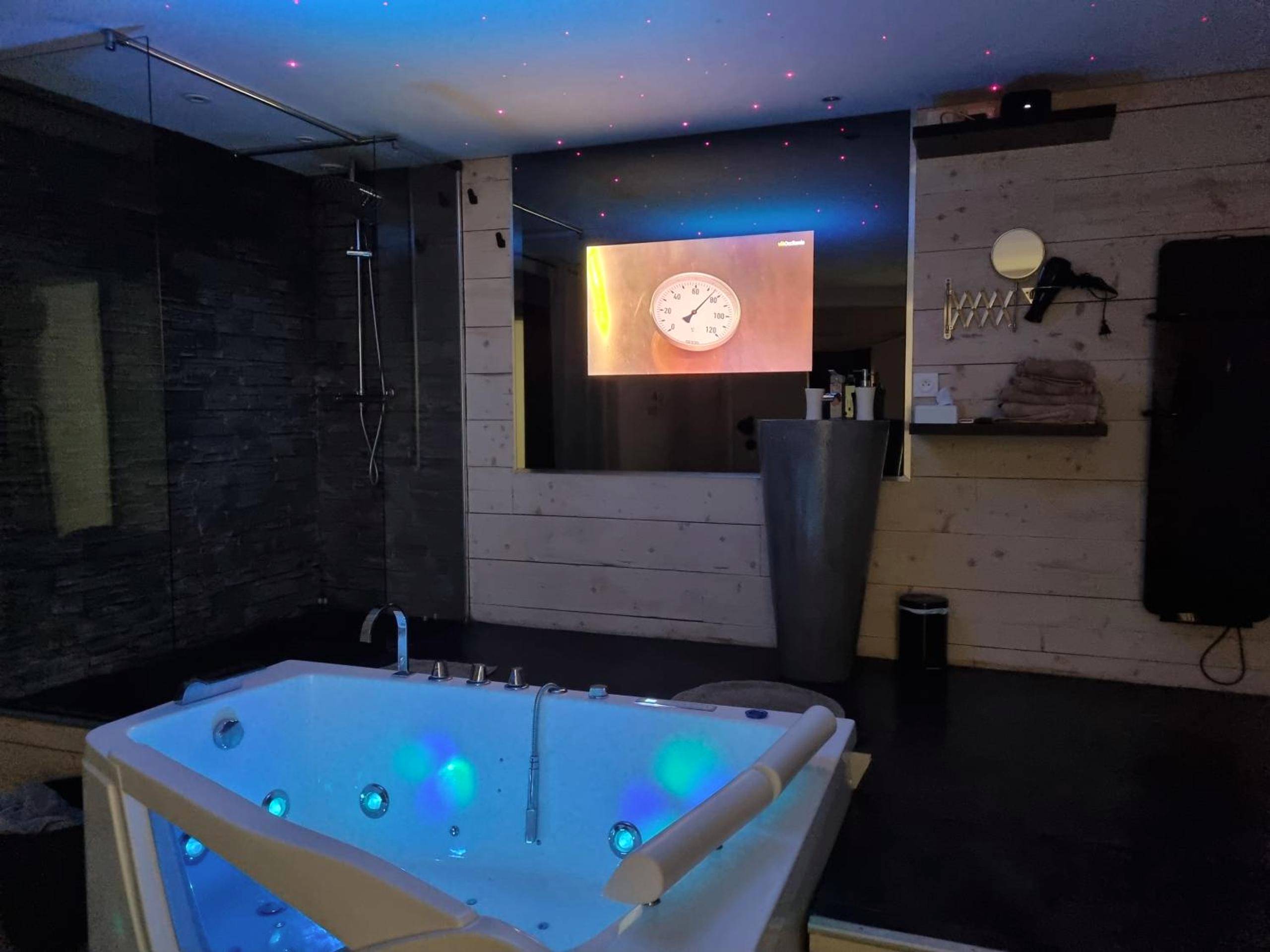 Jacuzzi illuminé sous un ciel étoilé - Love Loft