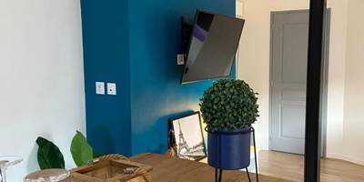 Coin repas avec table en bois et mur bleu - Lovely Apartment SPA & Sauna