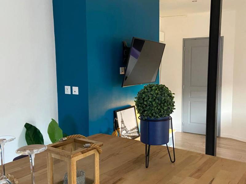 Coin repas avec table en bois et mur bleu - Lovely Apartment SPA & Sauna