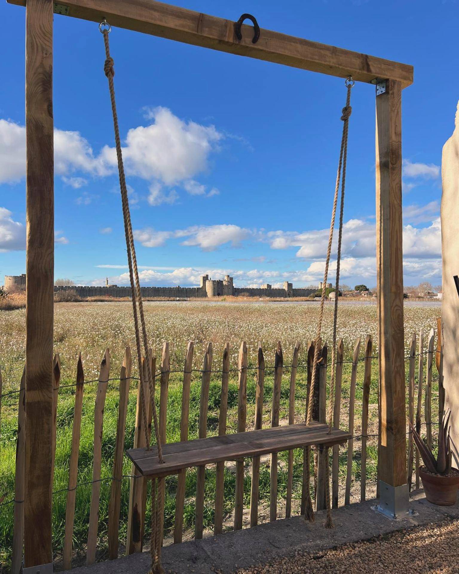 Balançoire en bois face aux remparts - L'Écrin d'Aigues - Loveness Suite & Spa