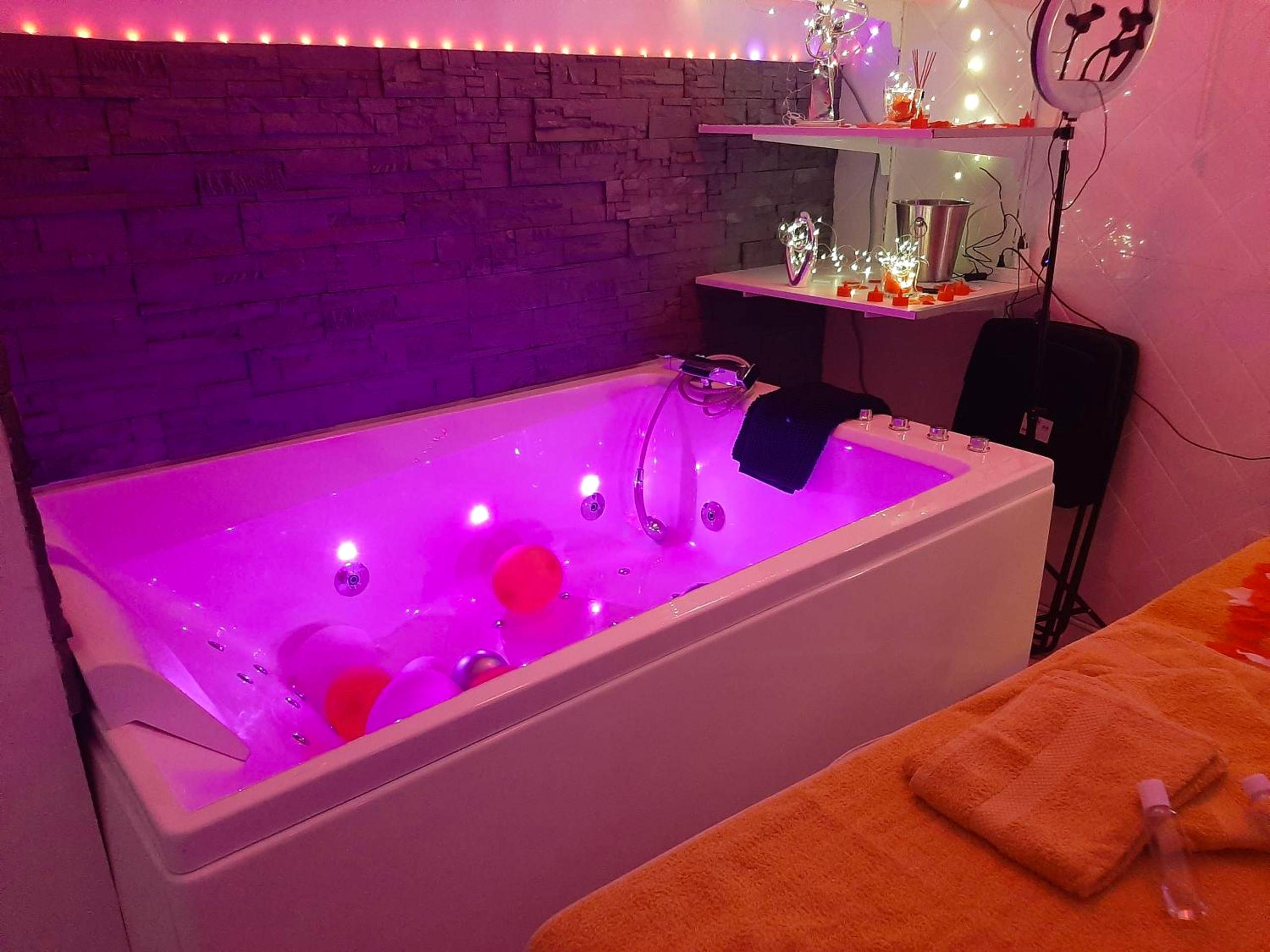 Baignoire balnéo avec éclairage rose et bougies - Love Room Toulon - la loveRomantique chez loveroomtoulon, parking et...