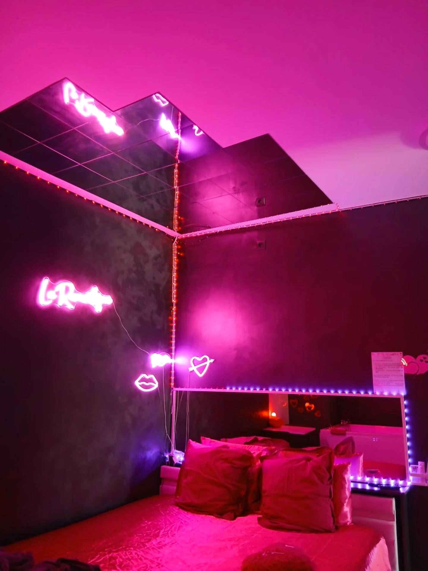 Lit double sous un miroir au plafond et néons - la loveRomantique chez loveroomtoulon, parking et wifi gratuits