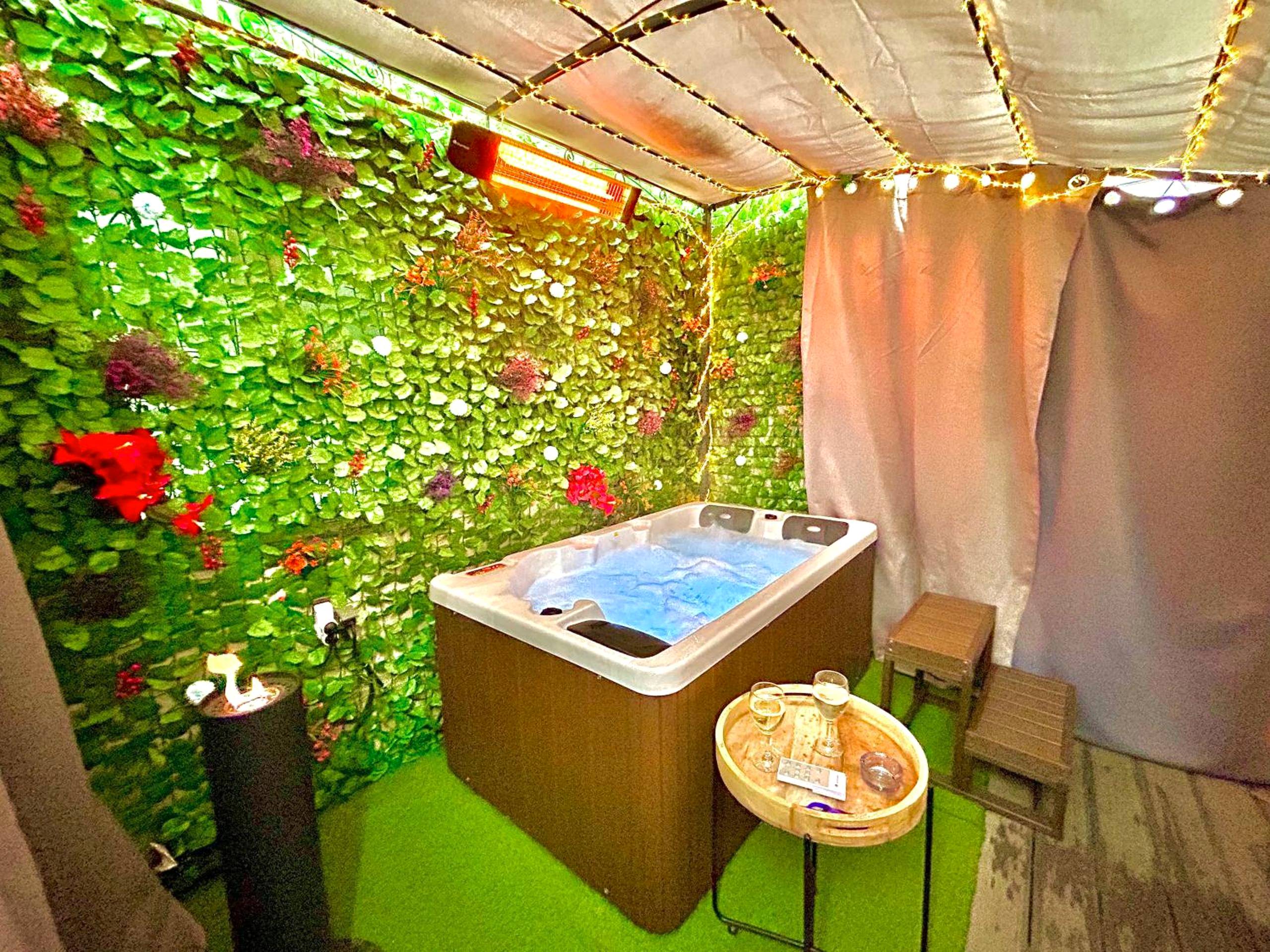 Espace détente avec jacuzzi et guirlandes - La lover’s jungle
