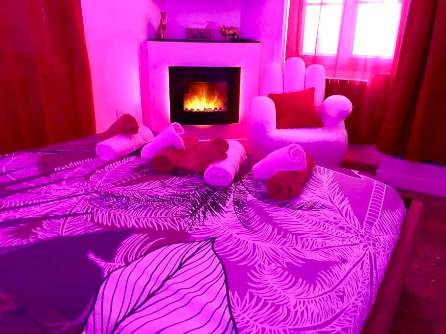 Lit avec serviettes et cheminée d'ambiance rose - La lover’s jungle