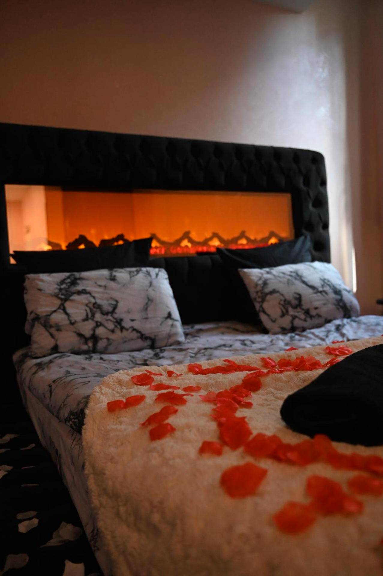 Lit double avec pétales de rose et cheminée - Love Time