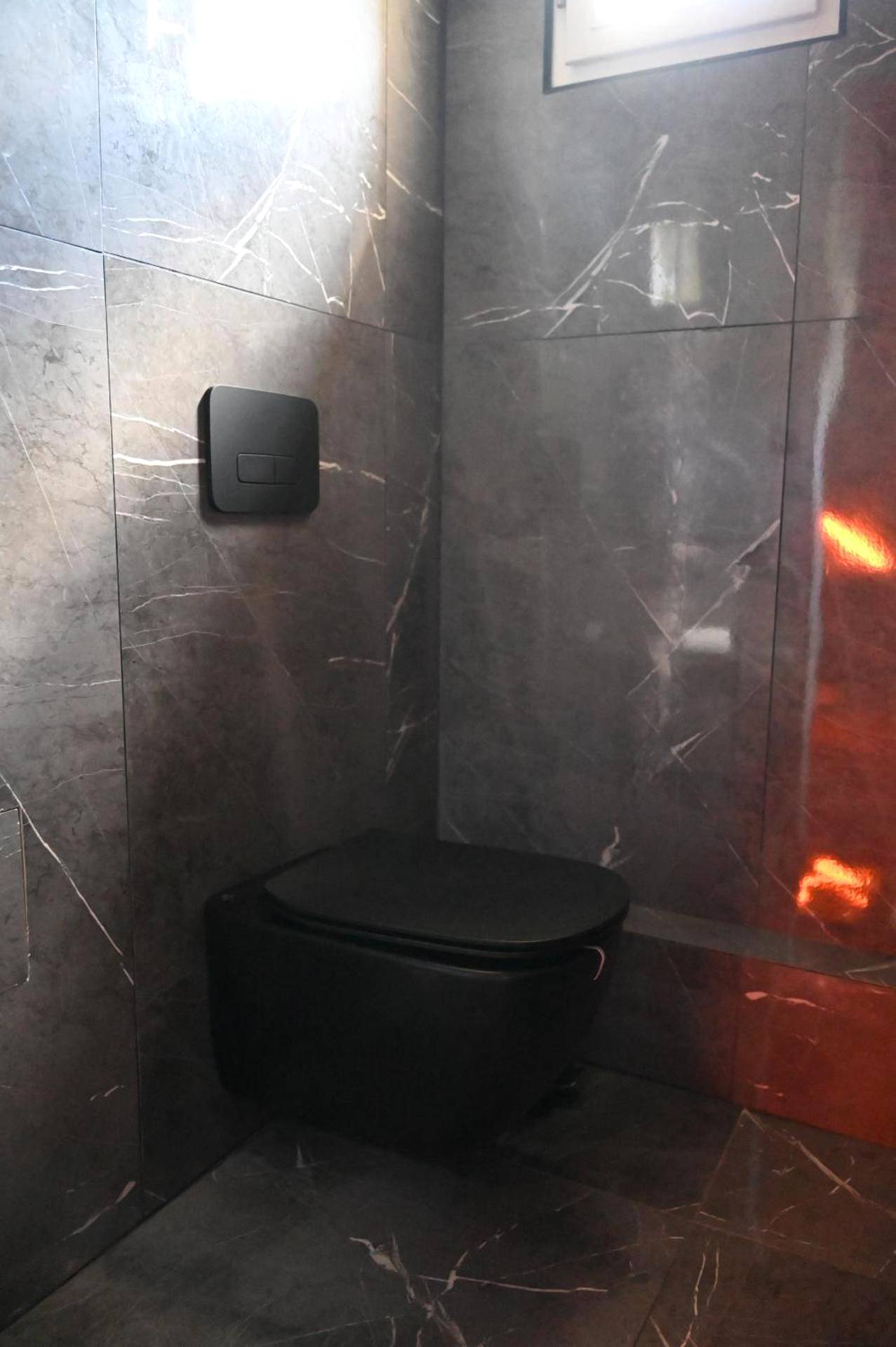 Toilettes suspendues noires et mur marbré - Love Time