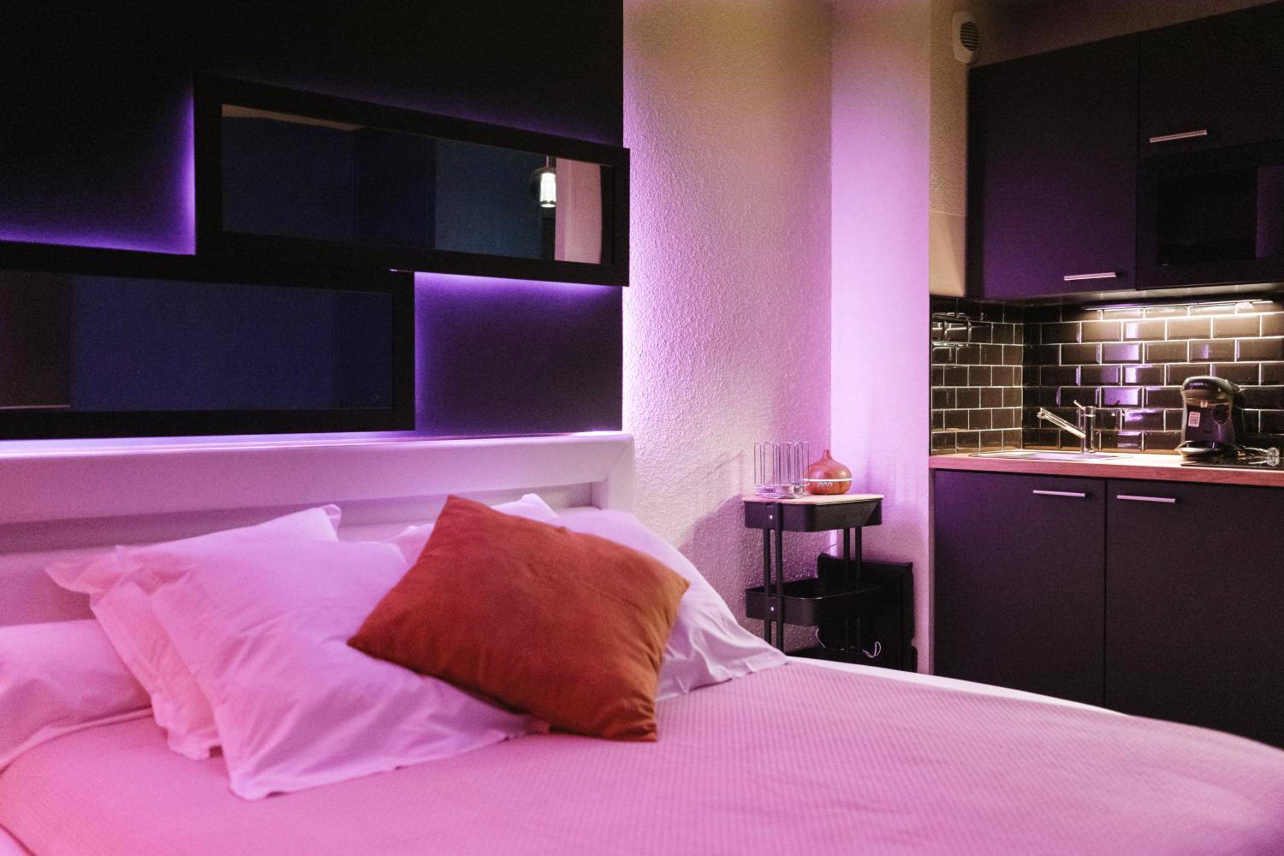 Lit double et coin cuisine avec néons violets - Love Room Perros - Guirec - LovRoz