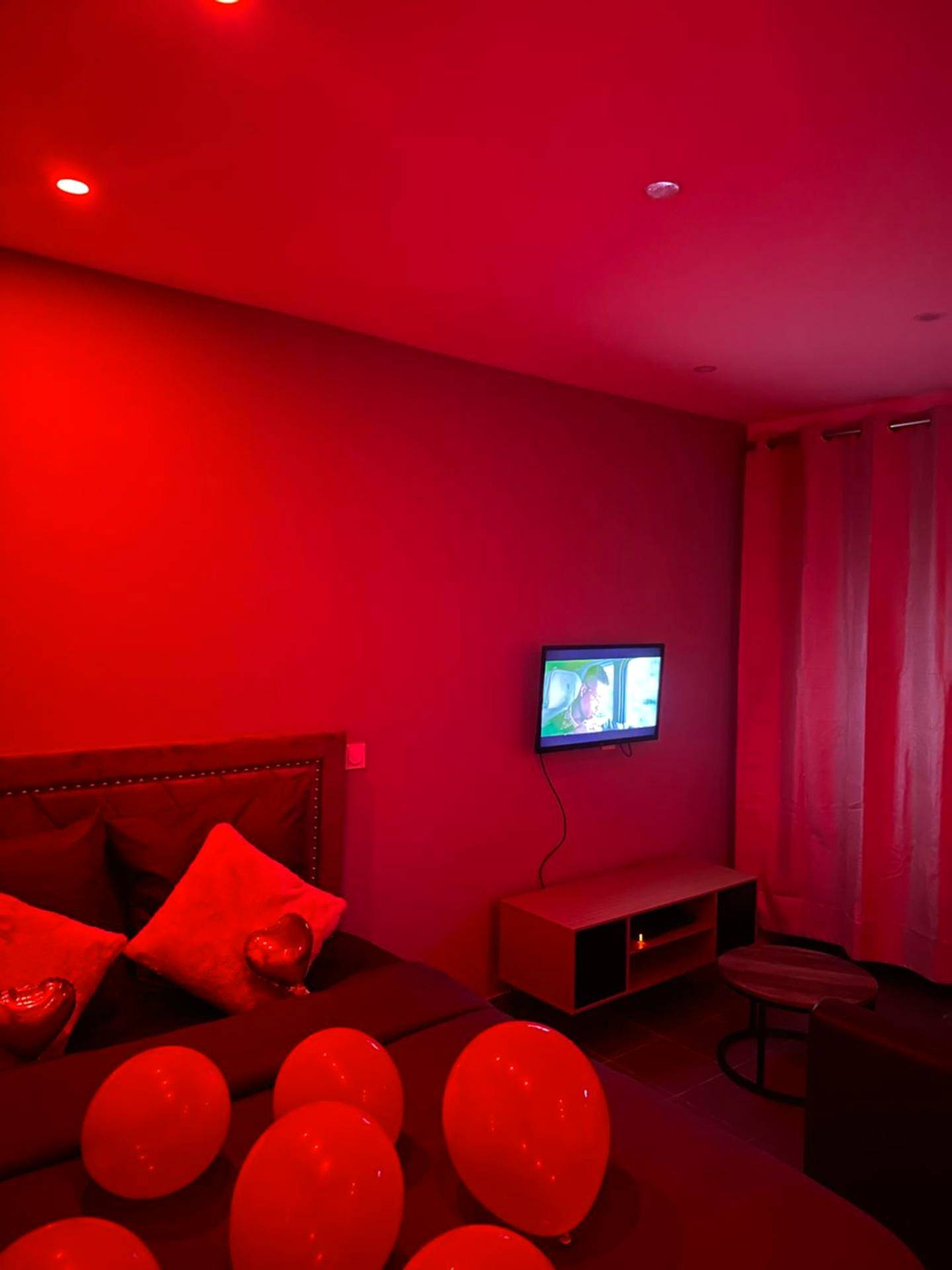 Chambre romantique avec ballons et lumière rouge - Lov’SPA 2