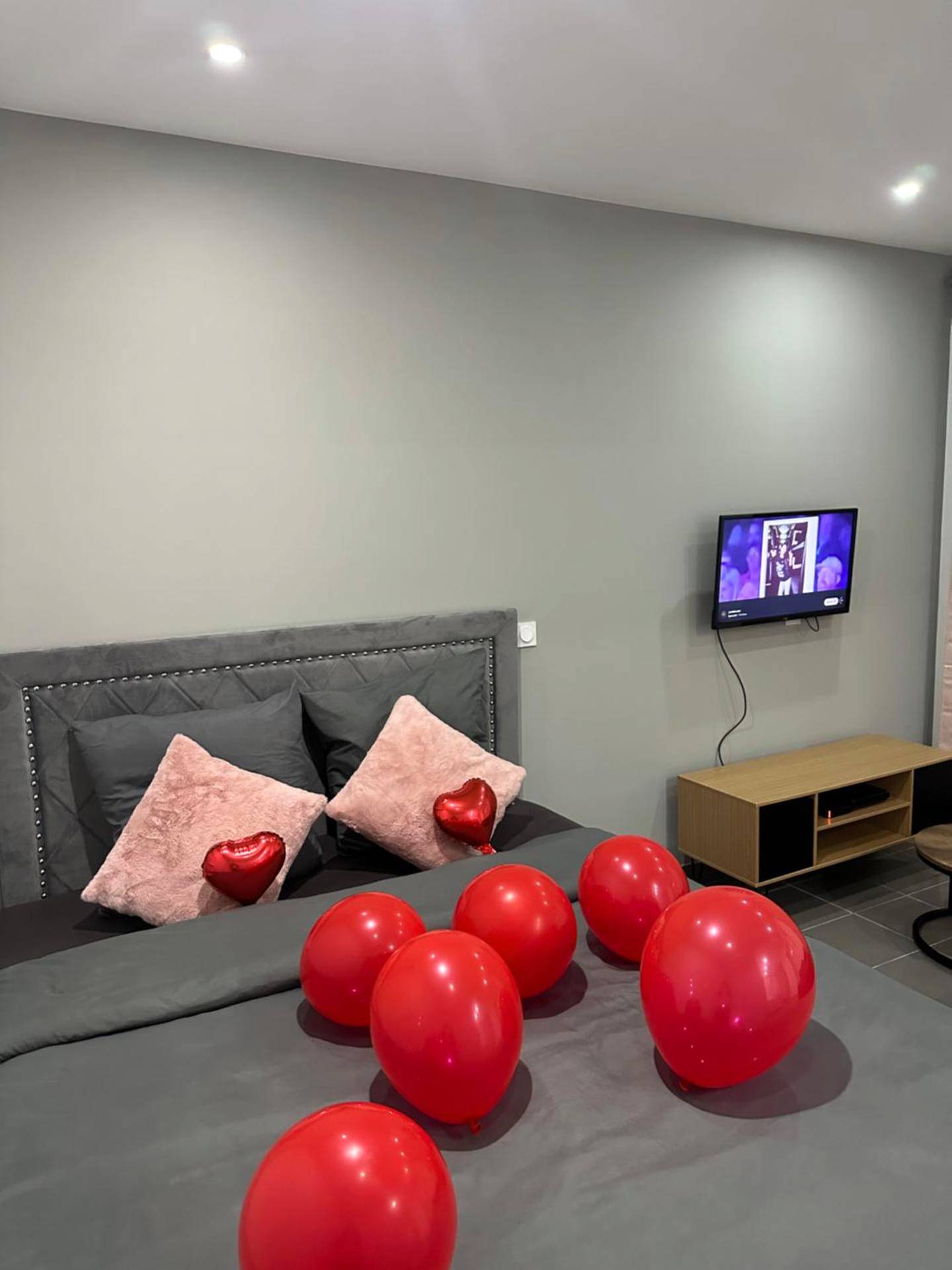 Lit double avec ballons rouges et télévision - Lov’SPA 2