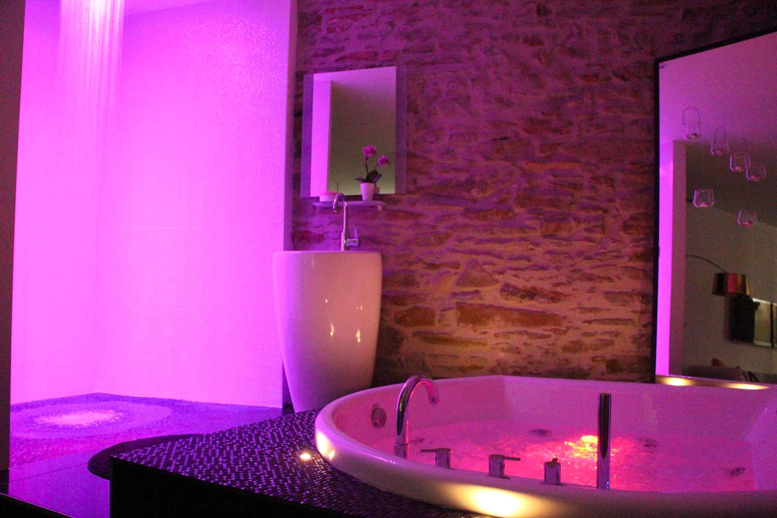 Jacuzzi privatif et douche sous néons violets - Le Lovt - LOVE ROOM NANTES