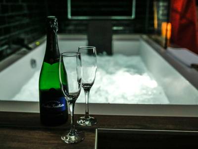 Bouteille de champagne et flûtes devant le spa - Love Room Condé - Sainte - Libiaire - Luxe and Spa