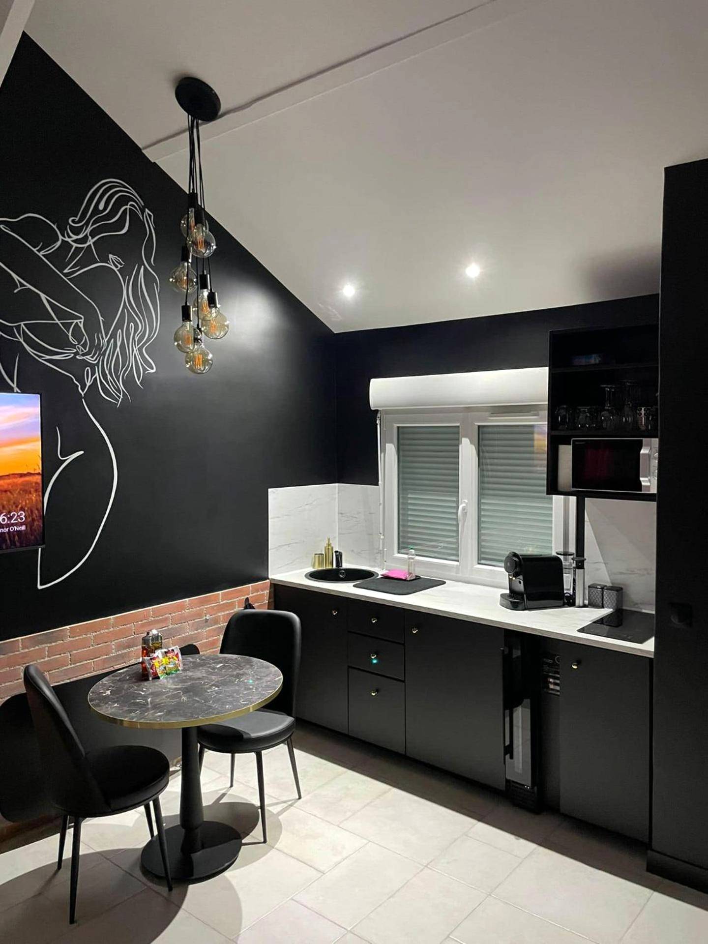 Cuisine équipée noire et coin repas moderne - Luxe and Spa