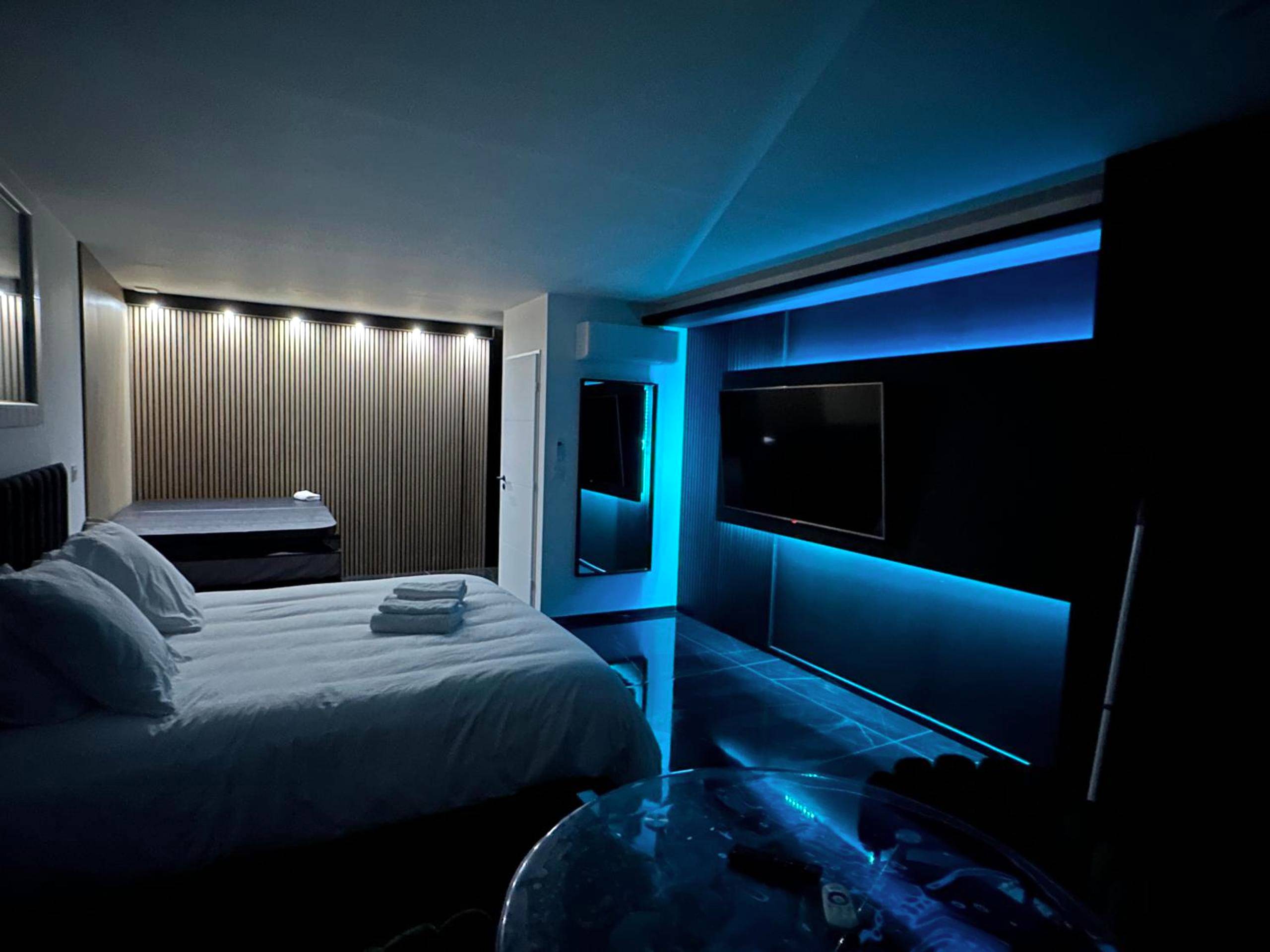Chambre avec éclairage LED bleu et grand écran - Love Room Martigues - Luxury Living Martigues