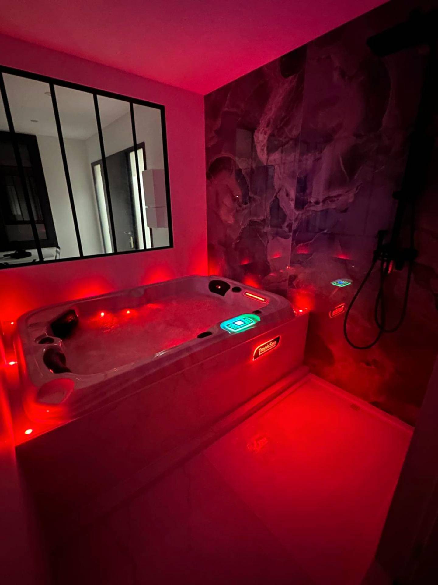 Jacuzzi privatif avec ambiance lumineuse rouge - Luxury Living Martigues