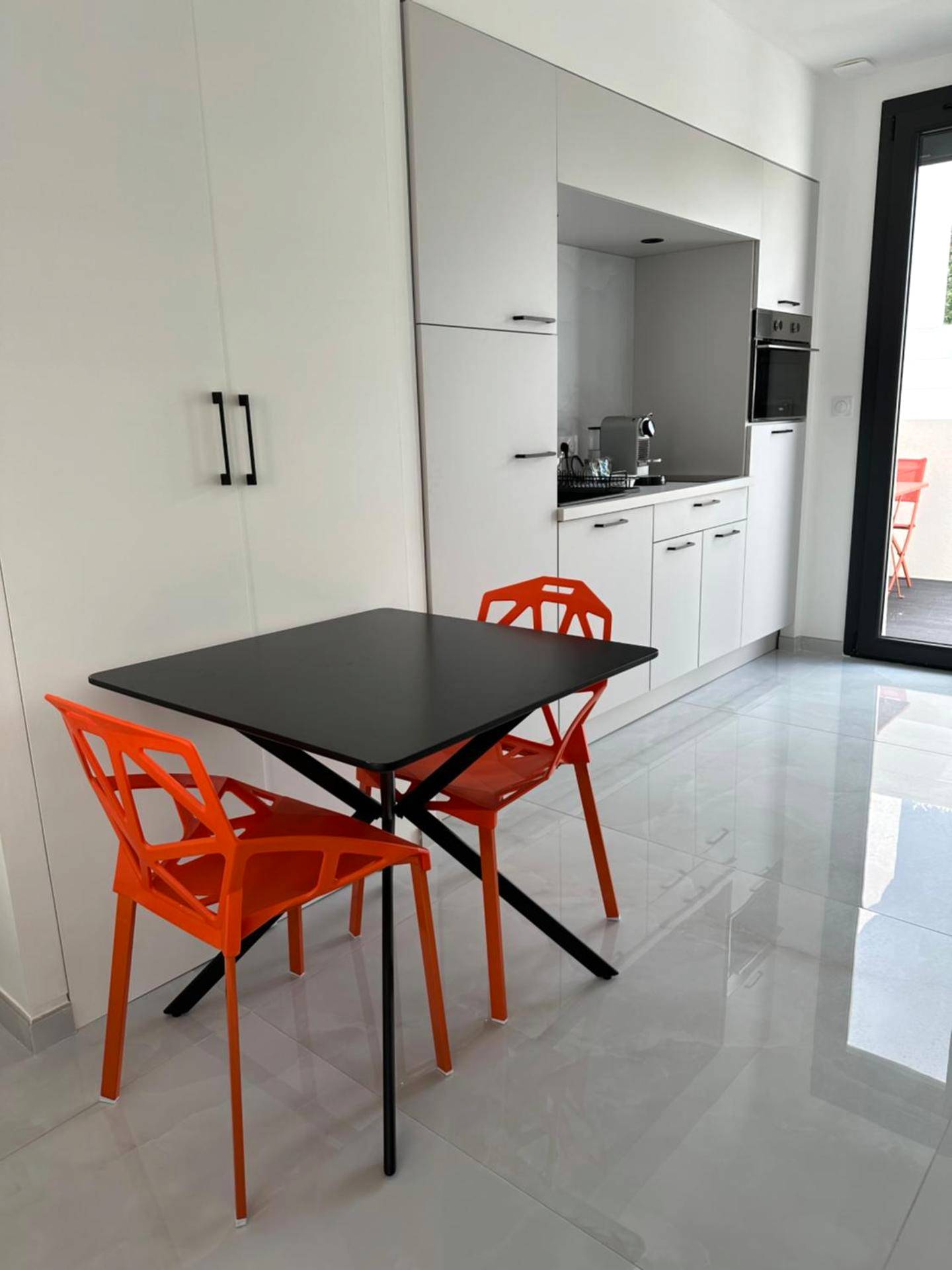 Espace repas moderne et cuisine équipée blanche - Luxury Living Martigues