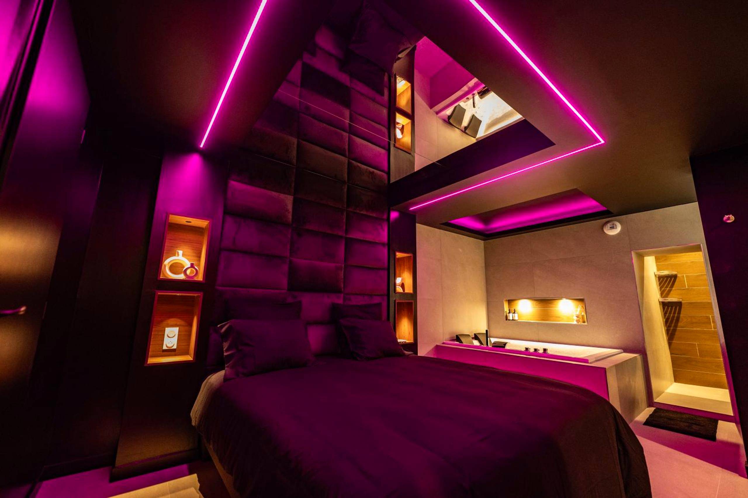 Lit double avec tête de lit capitonnée et néons - Love Room Clermont - Ferrand - LV Suites Jaude