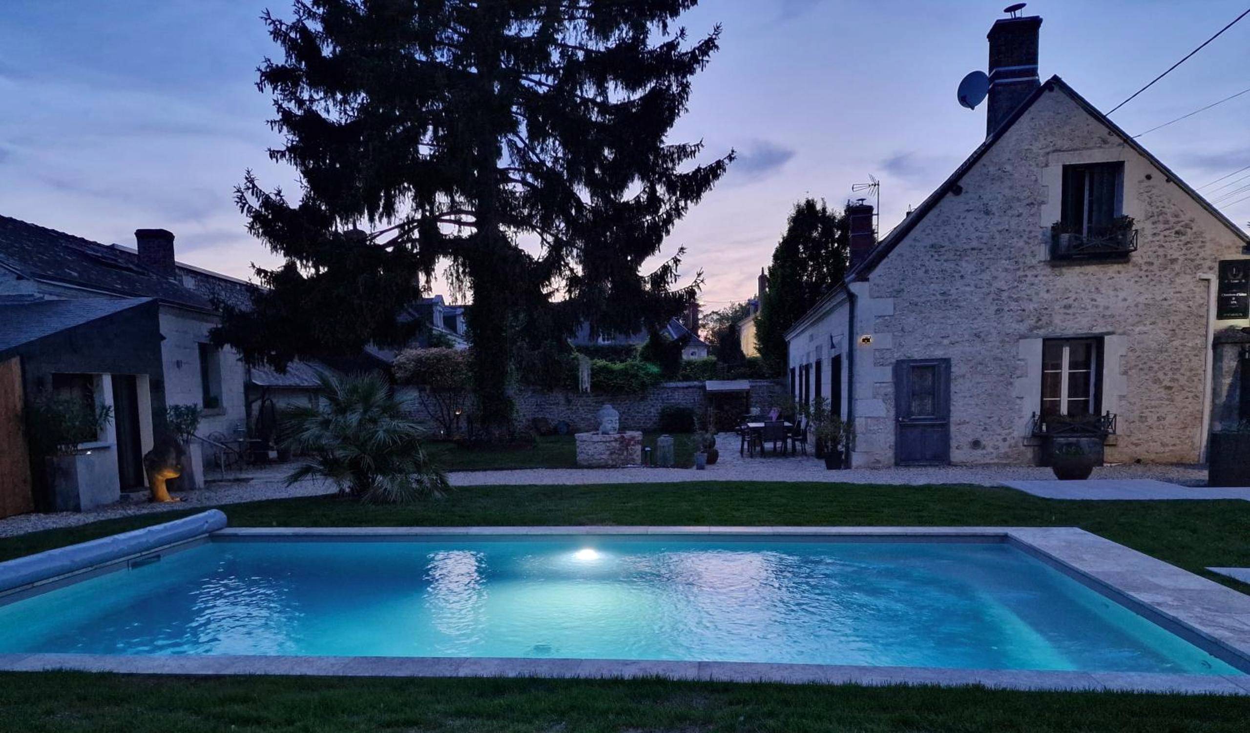 Piscine extérieure éclairée et jardin au crépuscule - Lyzen