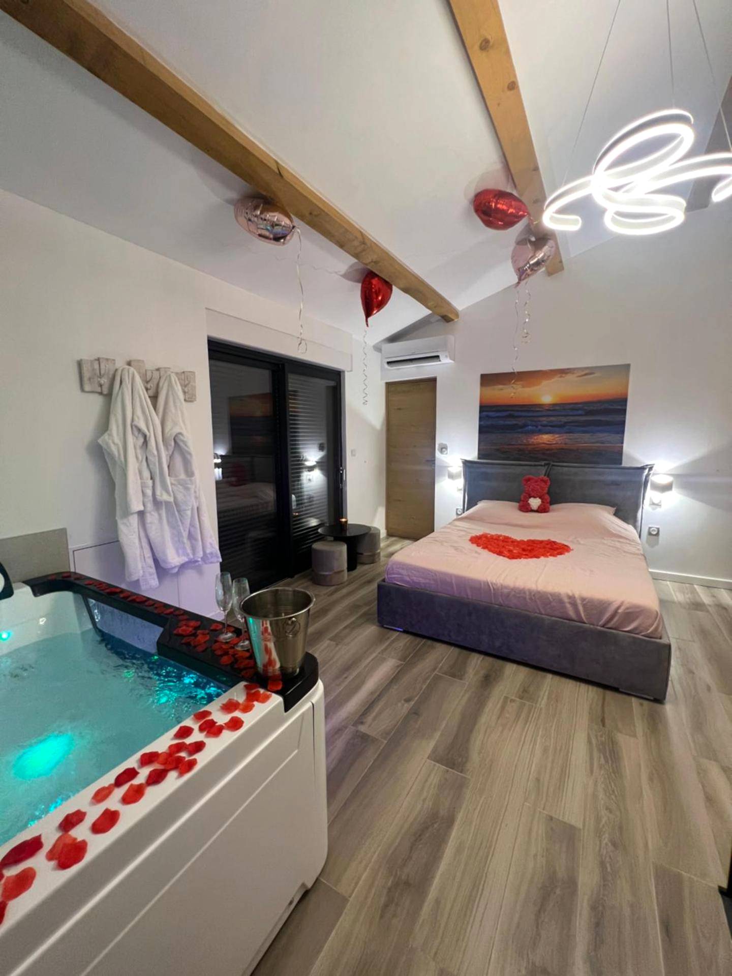 Baignoire balnéo et lit décoré de cœurs - Magnifique loveroom