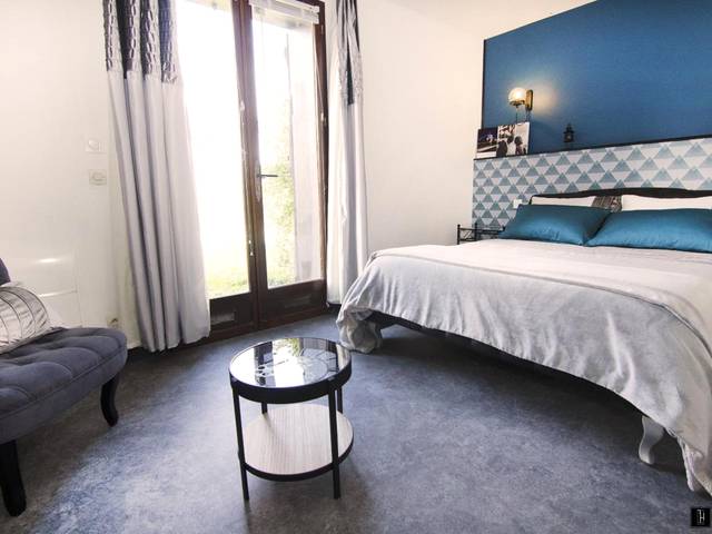 Chambre avec lit double et décoration bleue - Maison des Soupirs
