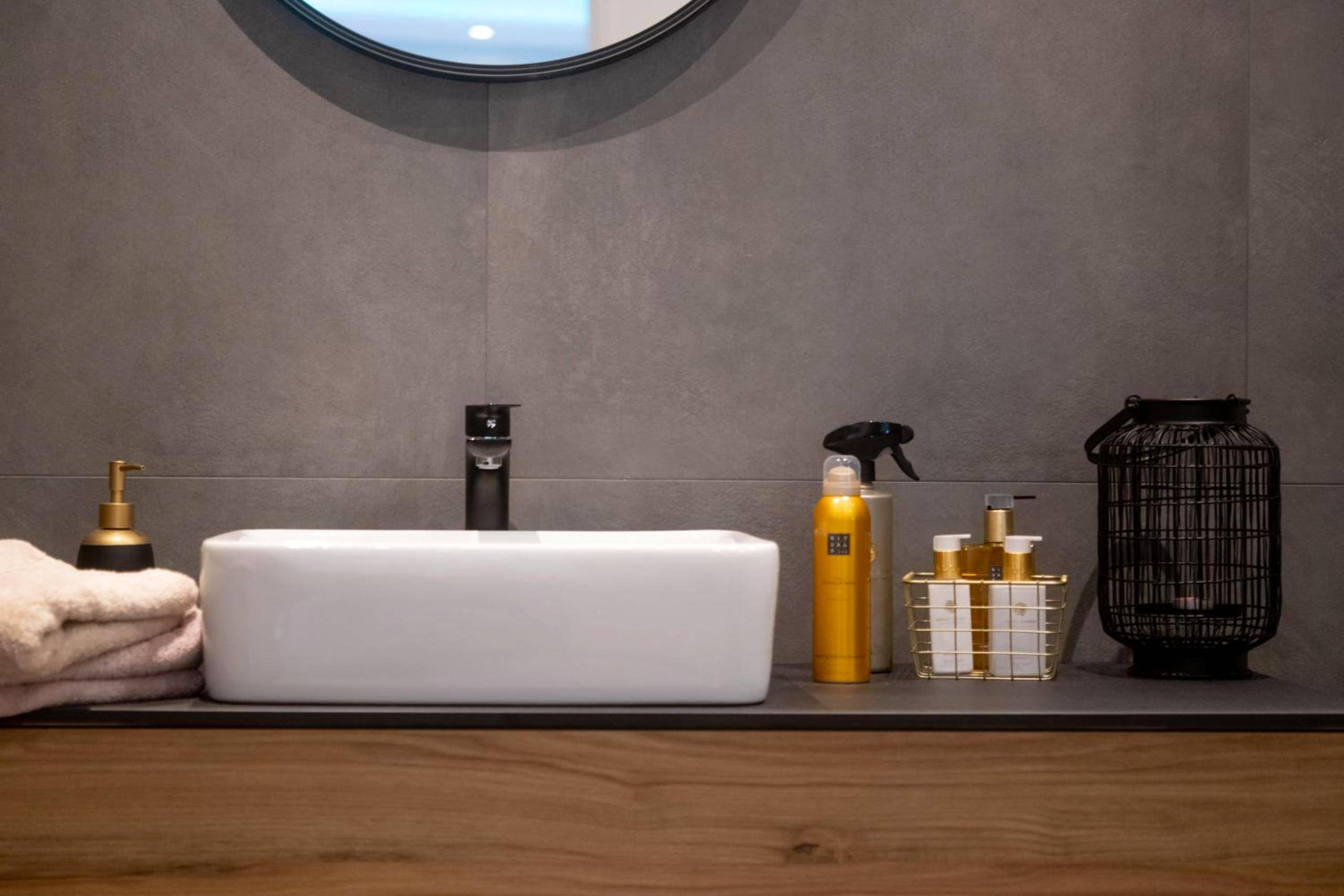 Vasque blanche sur meuble bois et produits d'accueil - MAISON AVEC SPA PRIVATIF ( JACUZZI ET SAUNA)