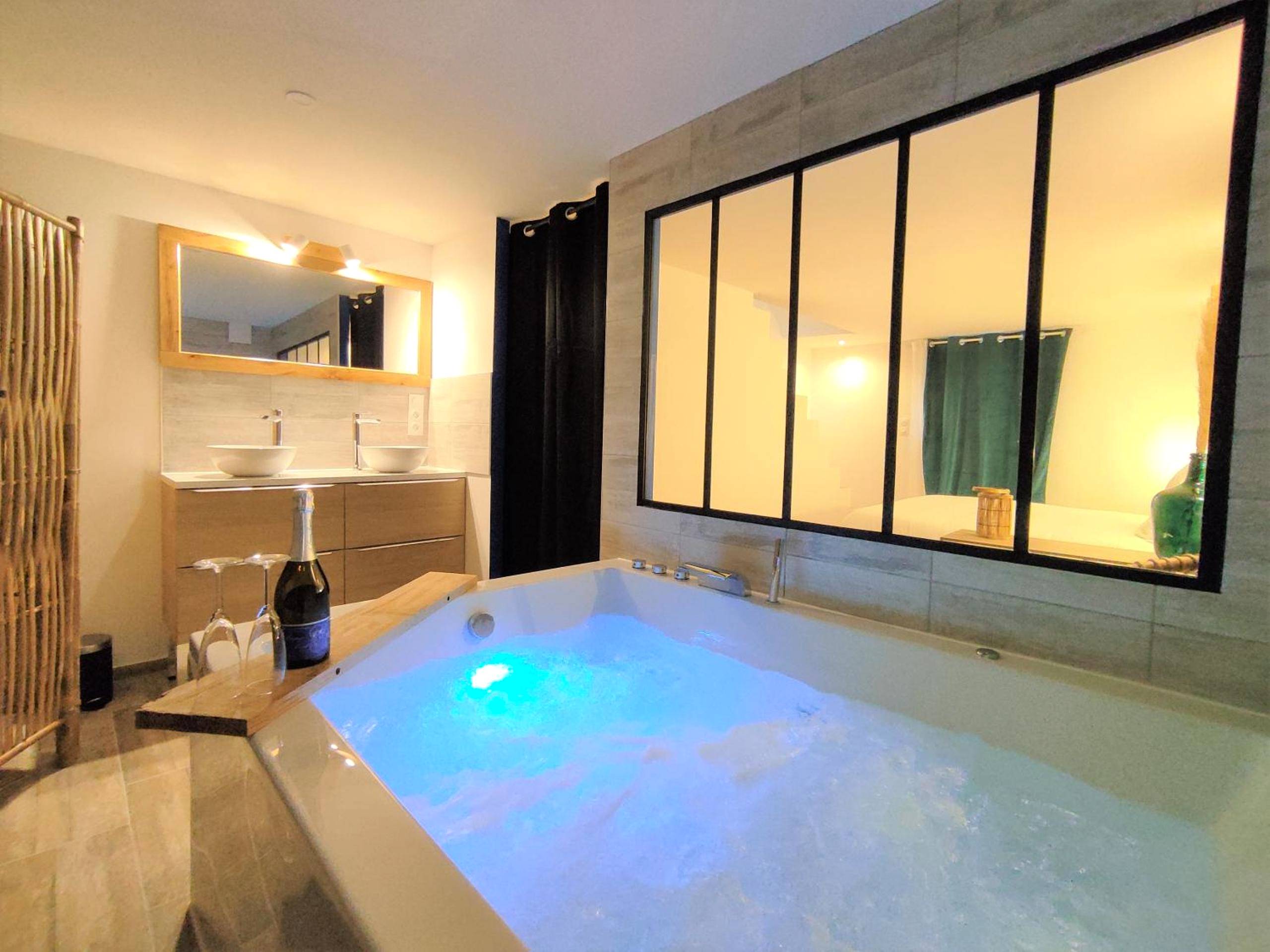 Jacuzzi privatif avec éclairage bleu et champagne - Love Room Vichy - Maison de ville, SPA Balnéo, 2 suites parentales