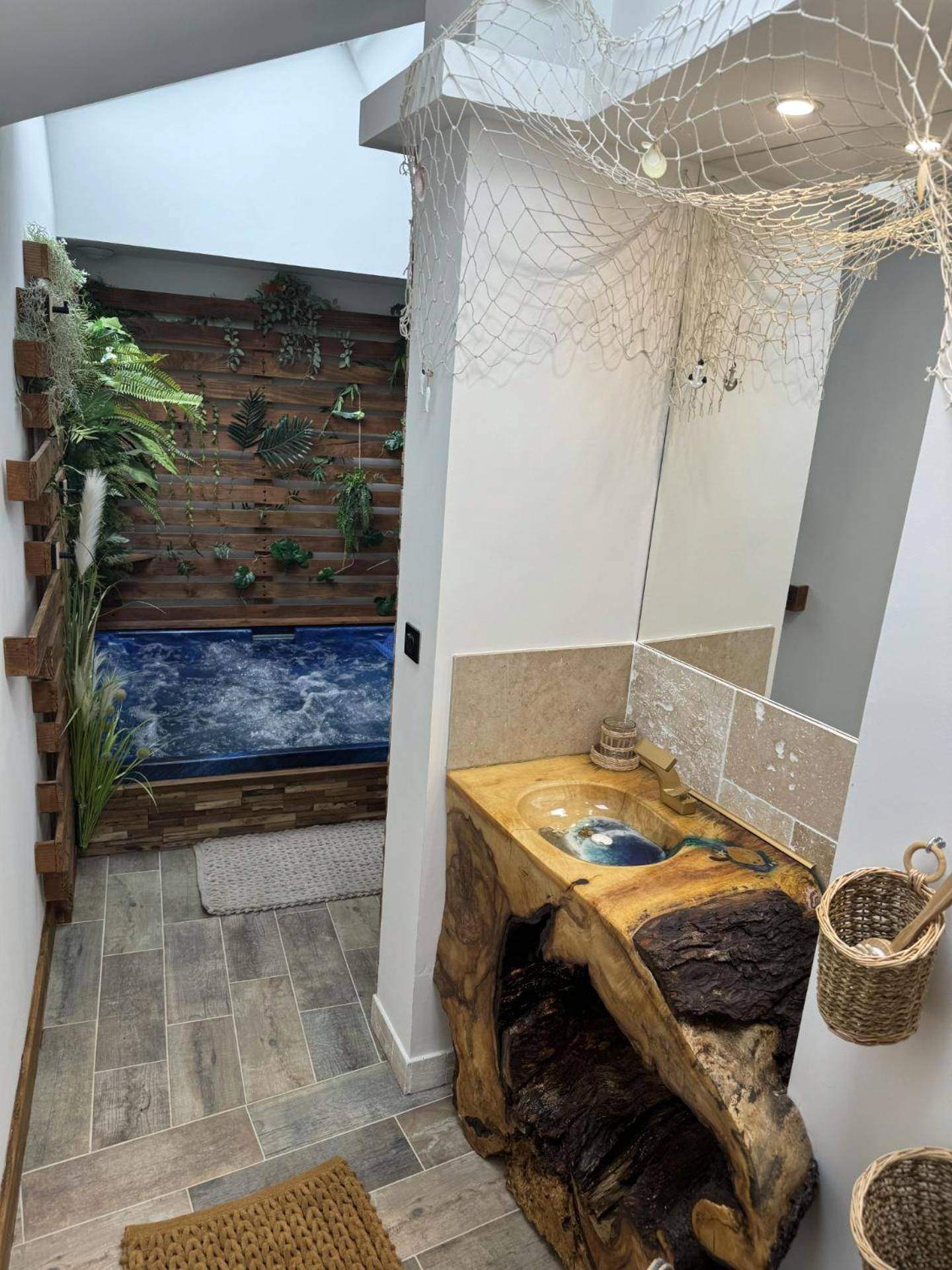 Meuble vasque en bois brut et jacuzzi au fond - La Maisonnette du Bien - Être