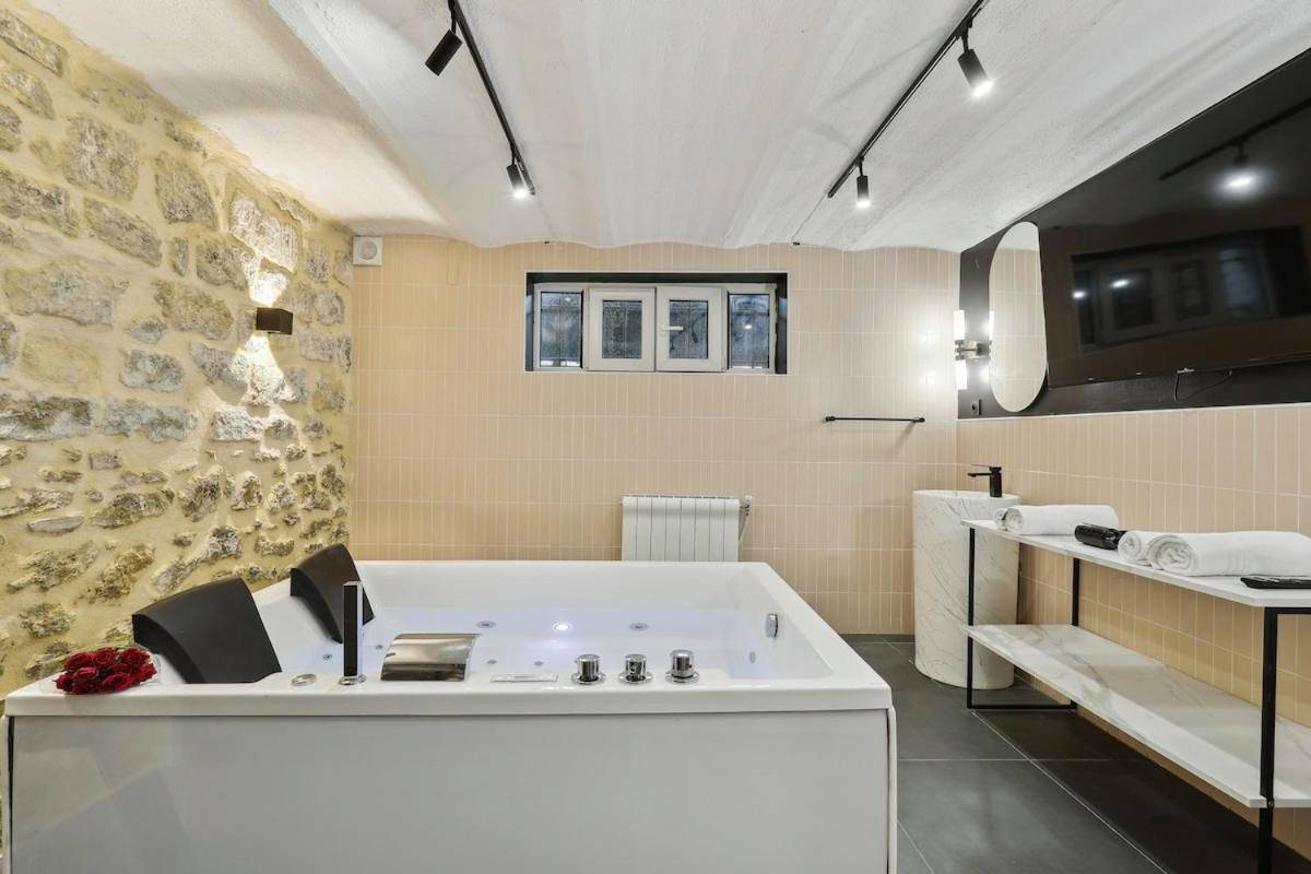 Baignoire balnéo face à un mur en pierre - Maisons Alfort 5 Luxurious apartment with private garden and Jacuzzi