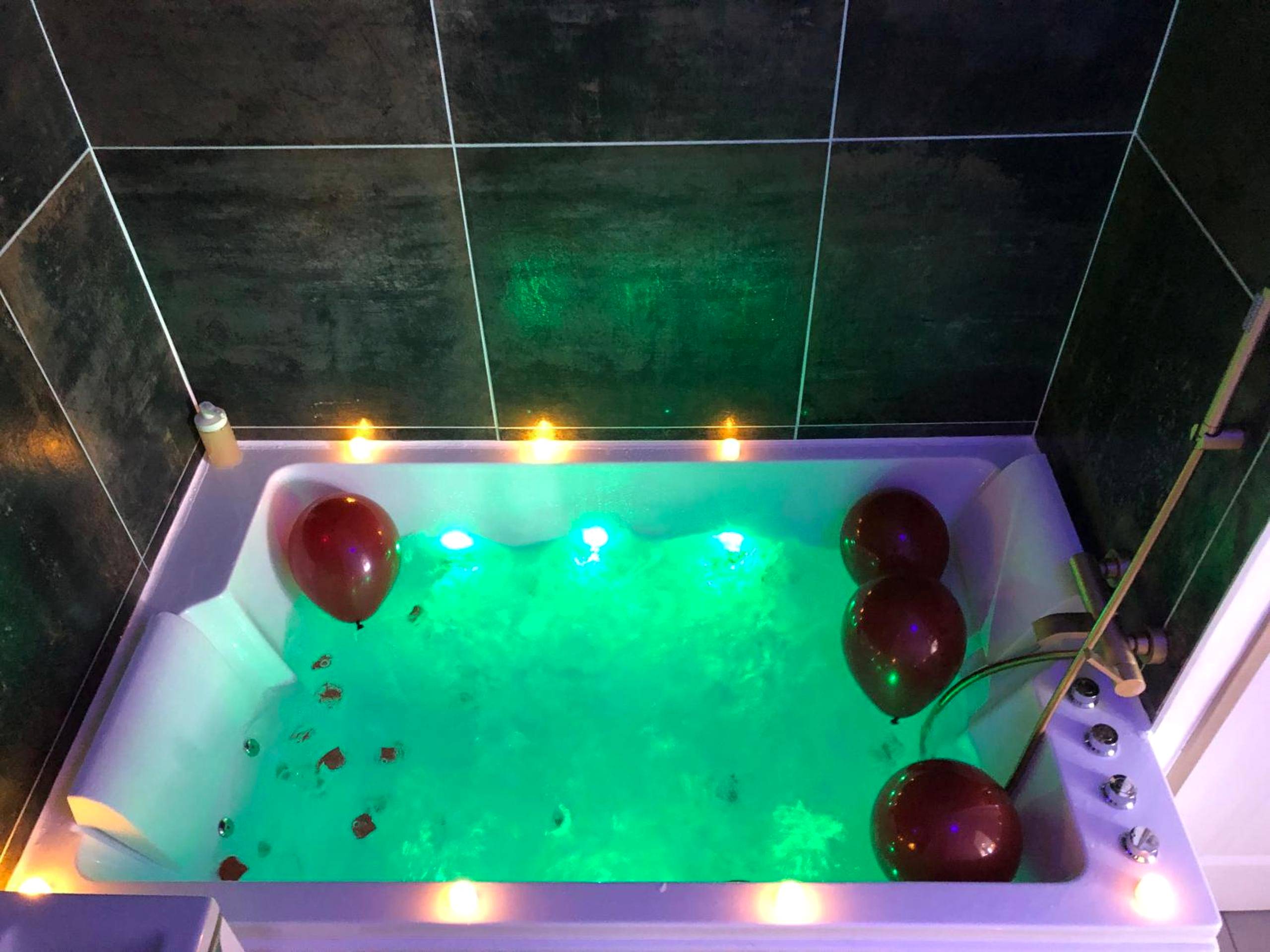 Jacuzzi avec éclairage vert et ballons rouges - Love room Malt&SPA jacuzzi privatif