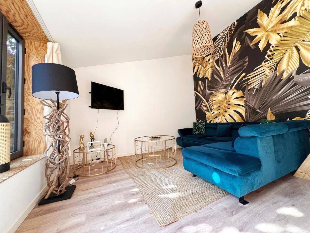 Salon avec canapé bleu et papier peint tropical - Le Manille