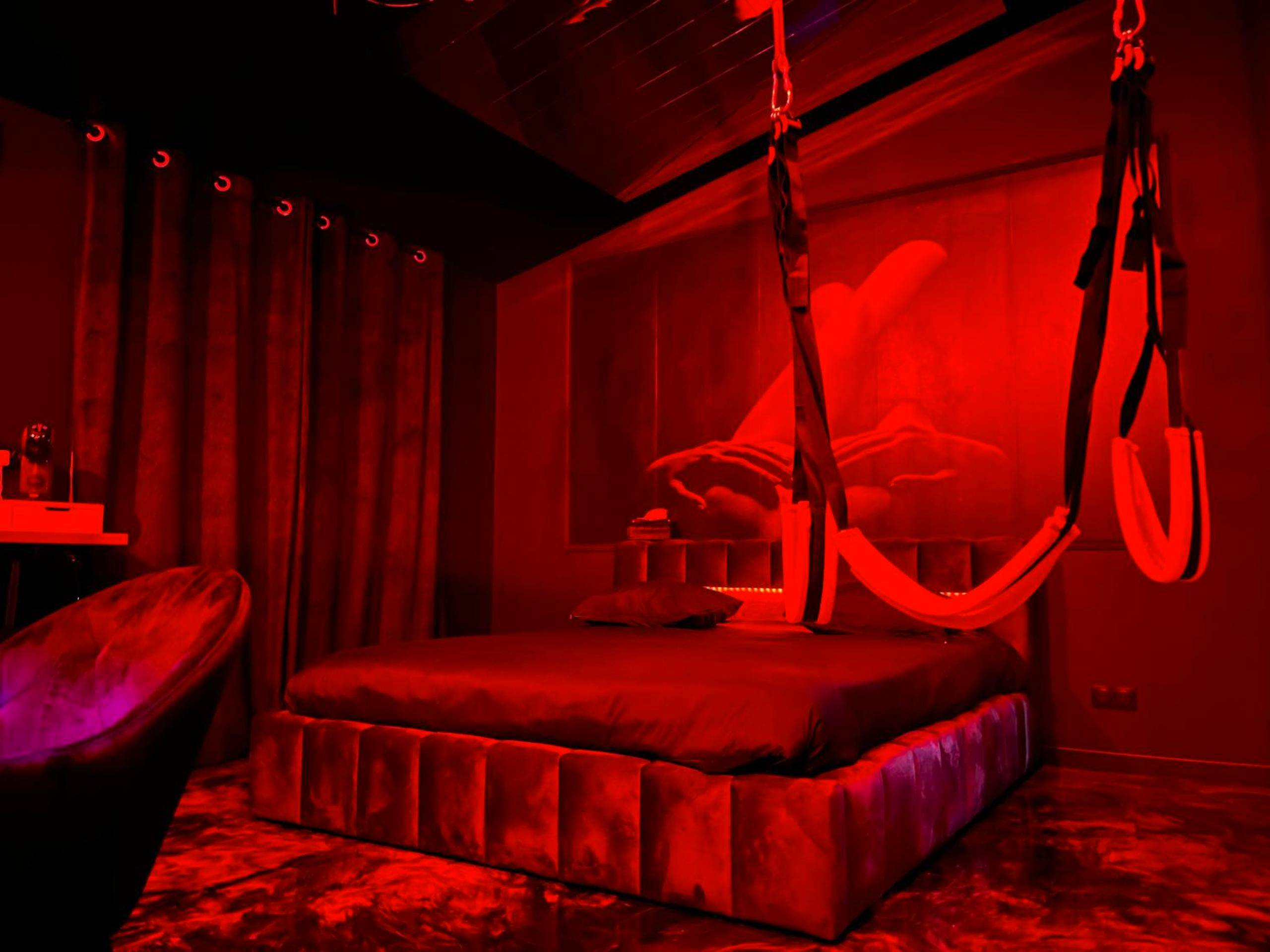 Chambre érotique avec balançoire et lumière rouge - Le Maquis Rooms