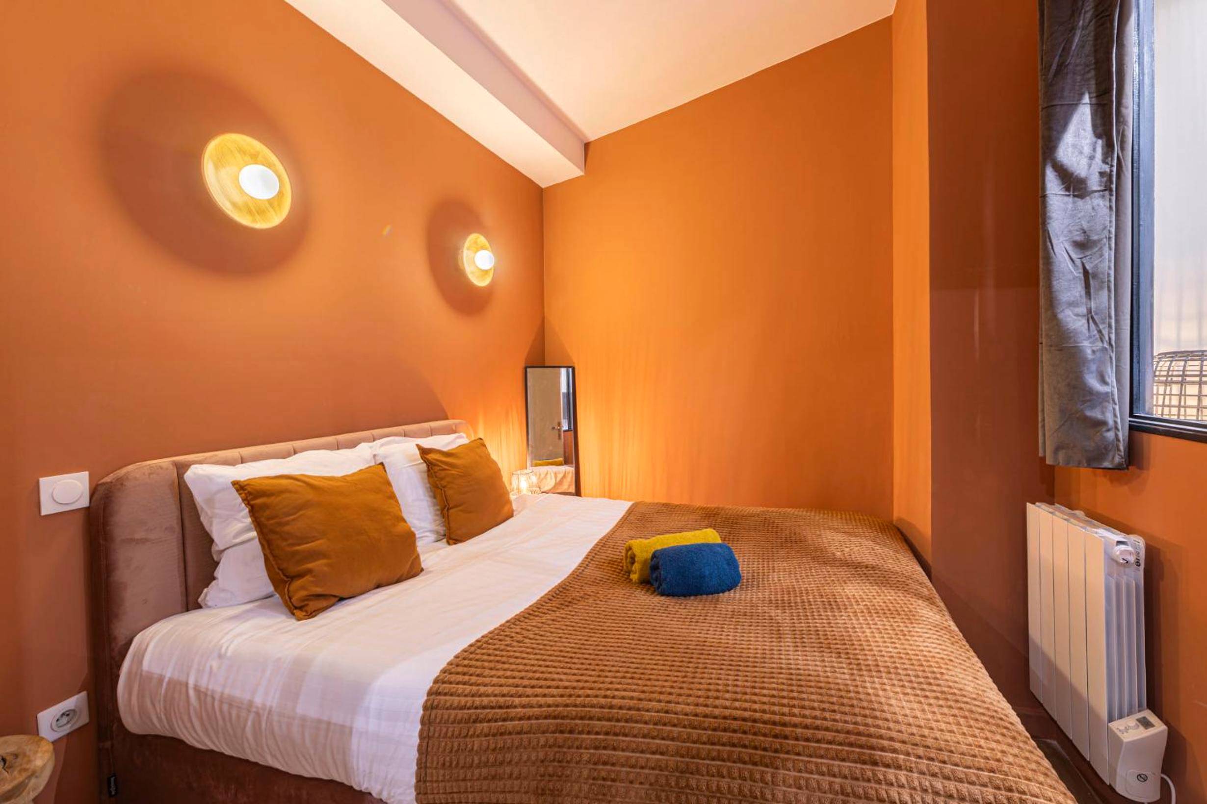 Lit double avec coussins terracotta et appliques - MARAIS POMPIDOU 3e, jacuzzi, 2 chambres, 4 à 6P