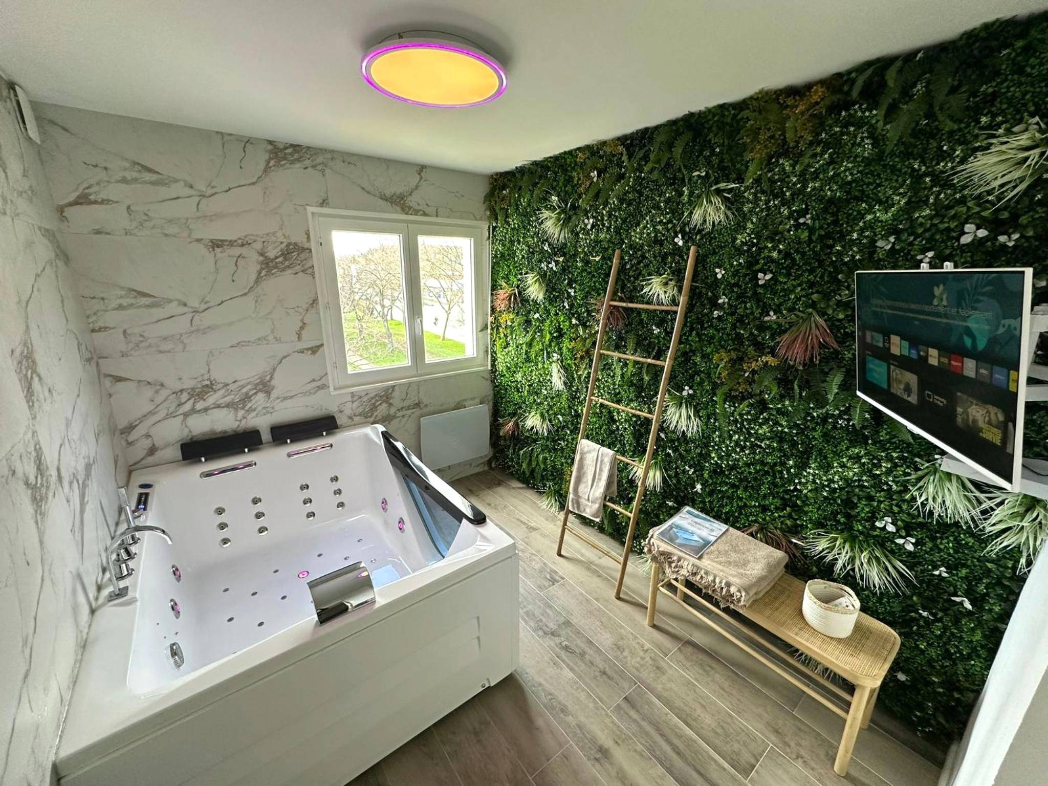 Baignoire balnéo devant un mur végétal - Love Room Obernai - MarbleMood Spa