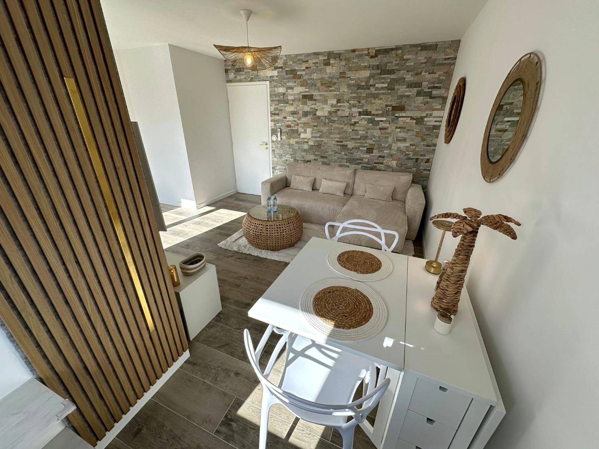 Salon avec canapé d'angle et mur en pierre - MarbleMood Spa