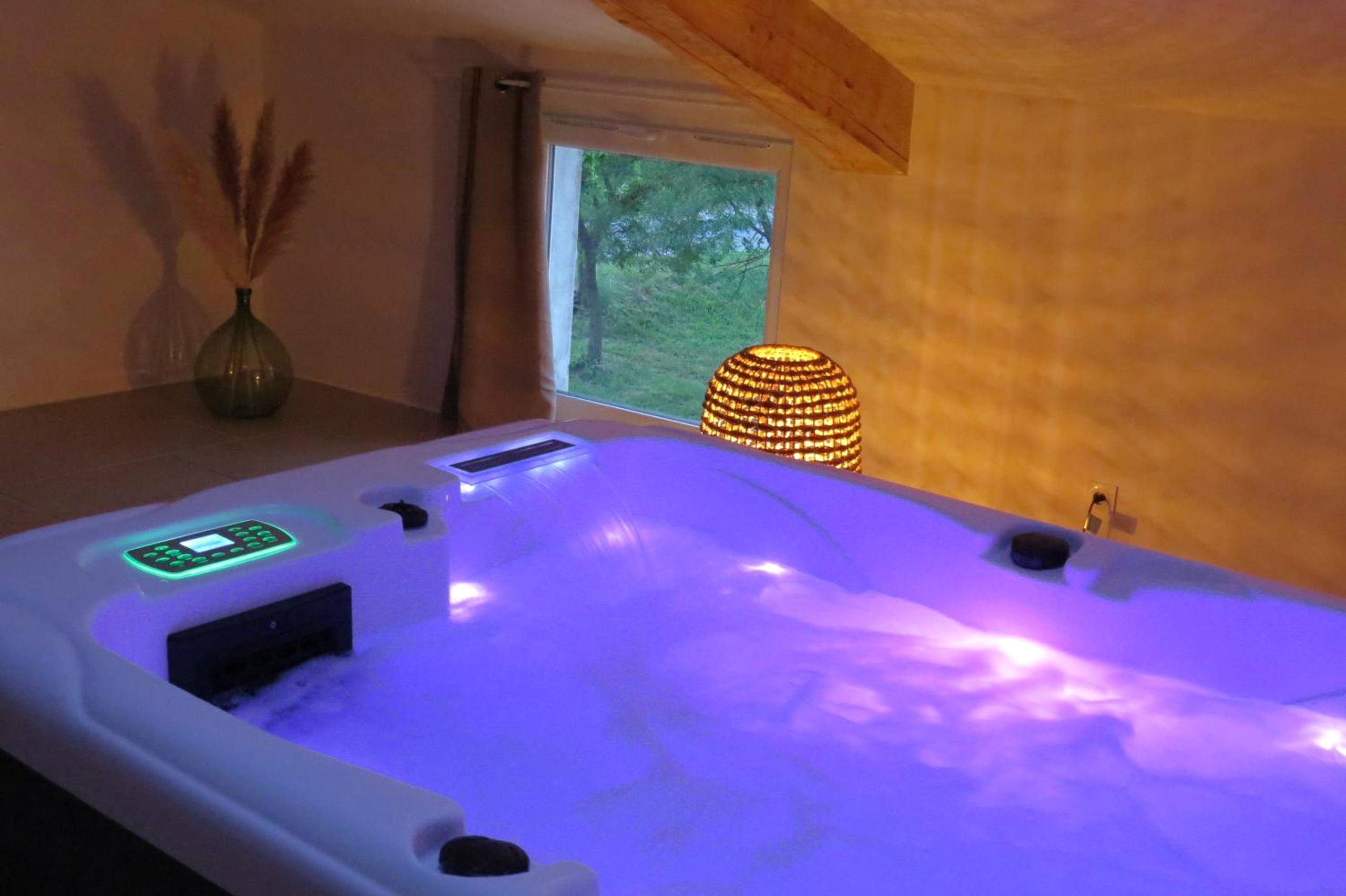 Jacuzzi privatif avec éclairage LED violet - Love Room Potelières - LE MAS de PAUL