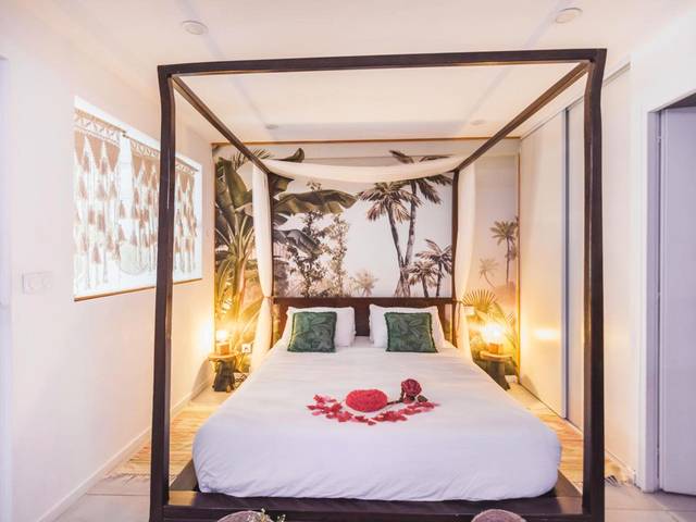 Lit à baldaquin avec pétales de rose - Gîtes Mas des rochers - Romance tropicale avec Spa