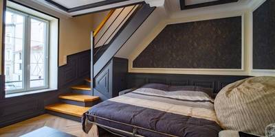 Lit double sous escalier et coin salon - Méga Jeanne d'Arc Billard Baby Foot en option Escape Game Logements Insolites