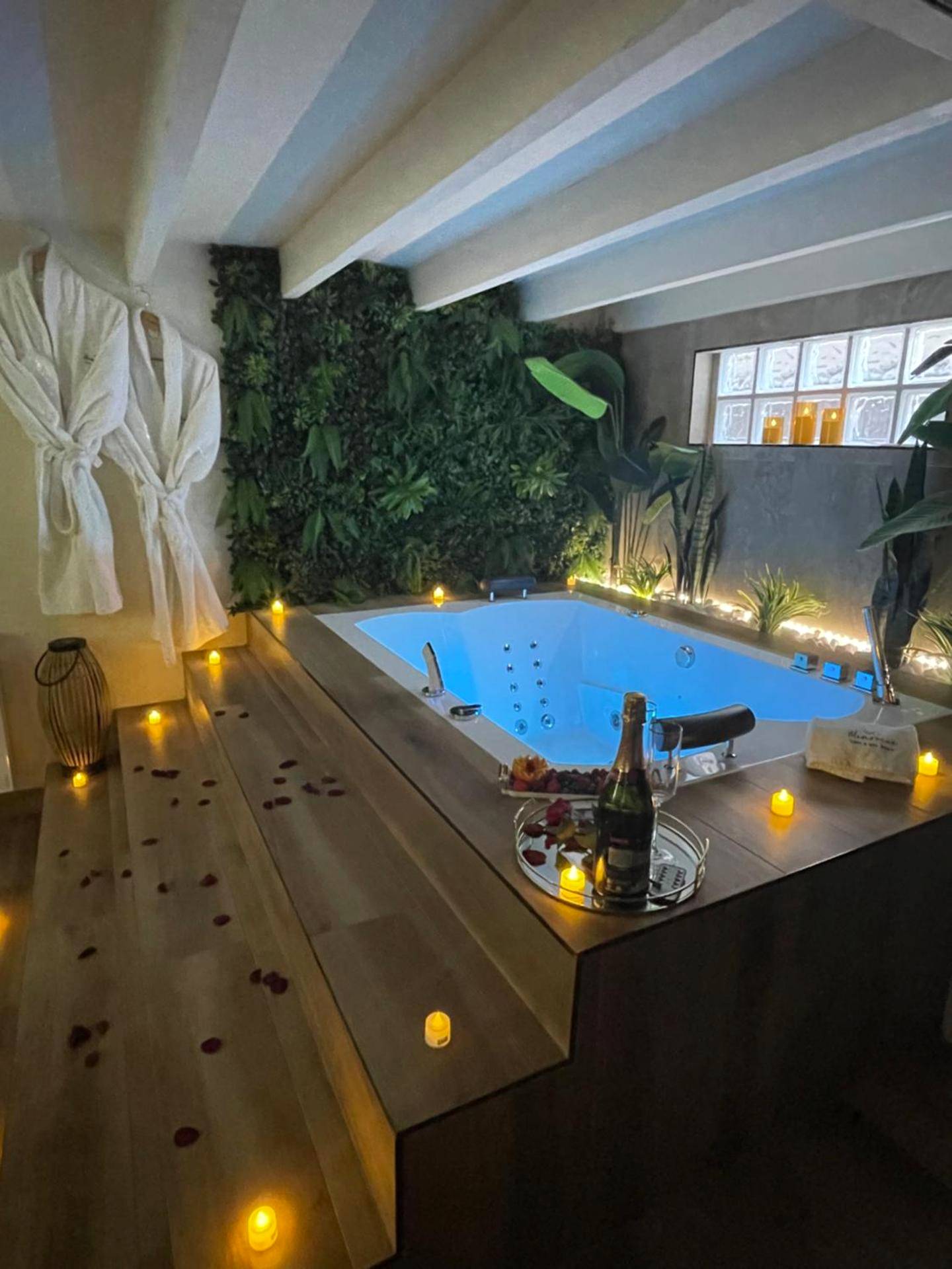 Jacuzzi entouré de bougies et mur végétal - Love Room Carrières - sur - Seine - Memories Loft and Spa - Paris