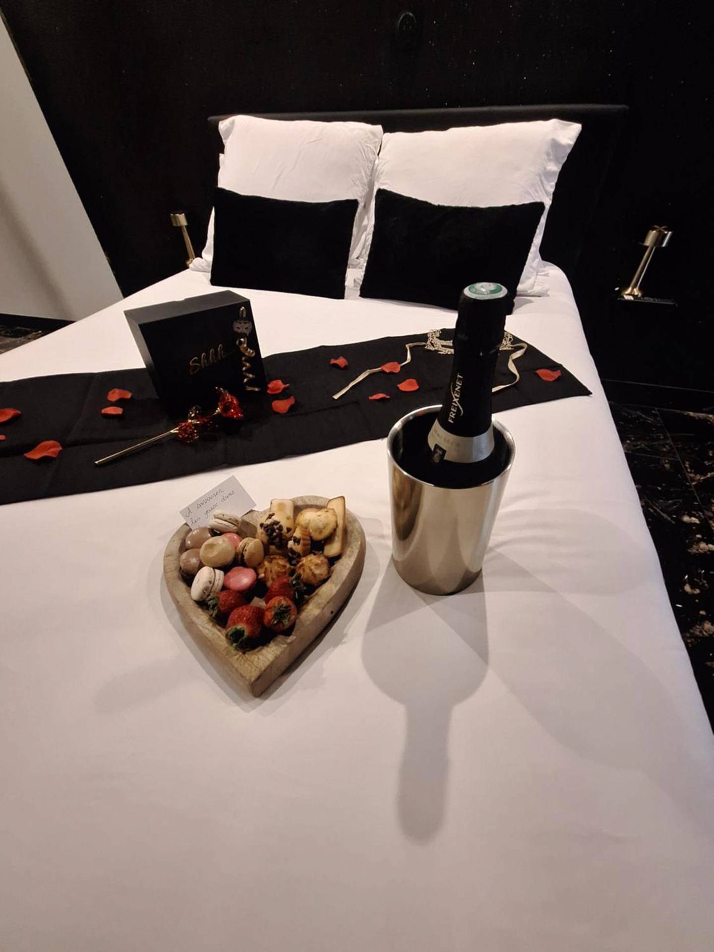 Champagne et mignardises sur le lit - love room mes petits secrets miniac morvan avec jacuzzi privatif