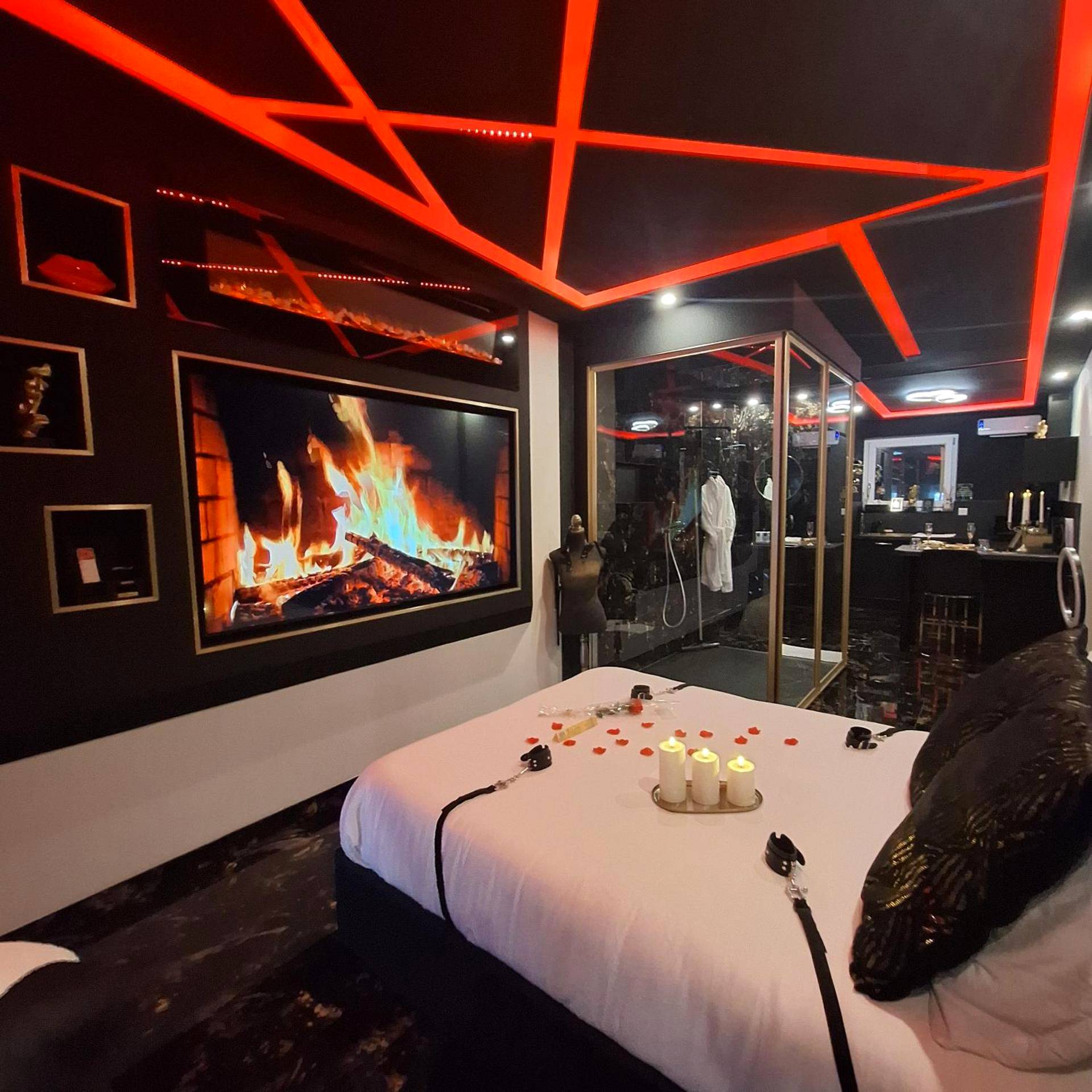 Écran feu de cheminée face au lit avec menottes - love room mes petits secrets miniac morvan avec jacuzzi privatif