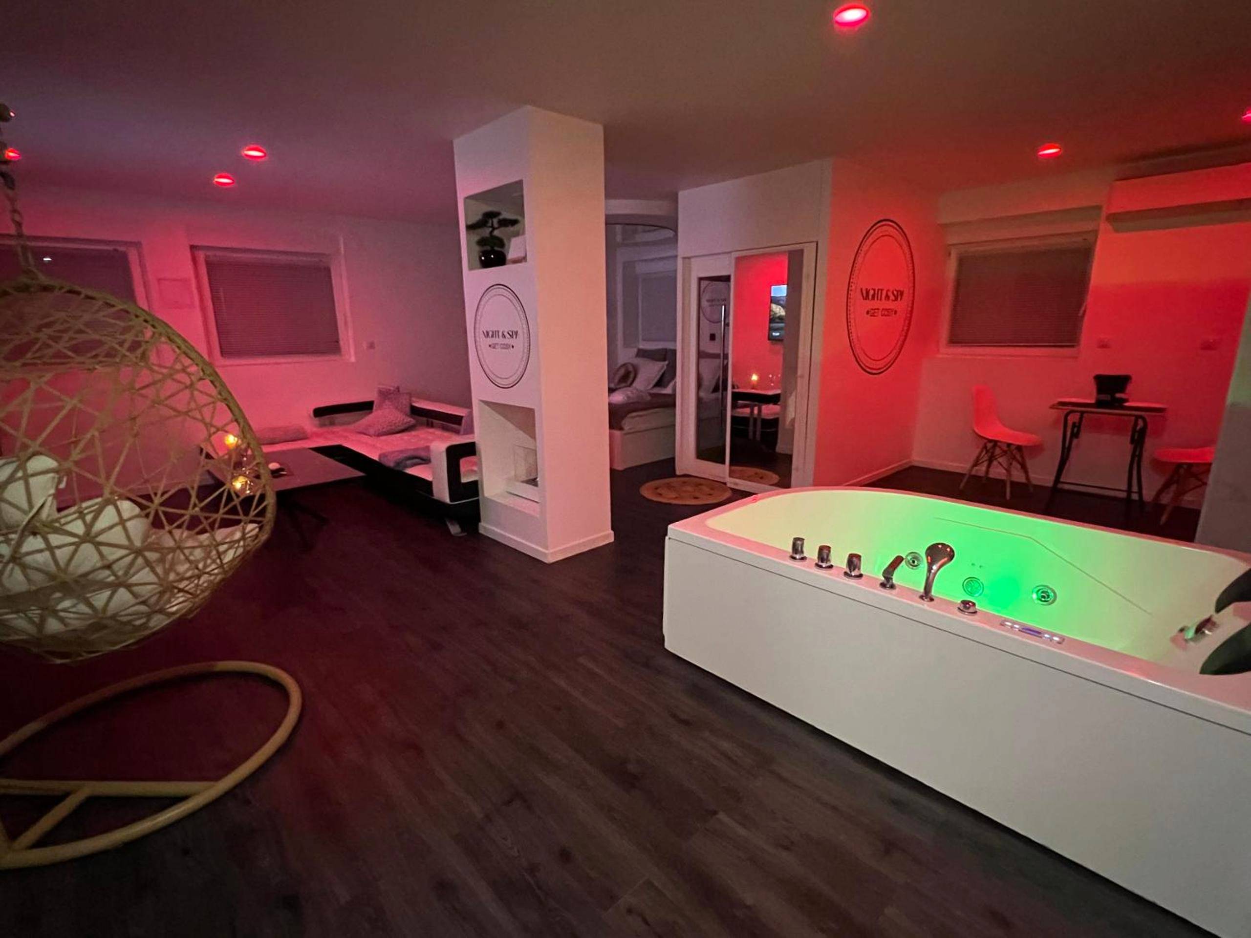 Jacuzzi privatif et salon avec lumière rose - Love Room Metz - Metz Détente Un Séjour à Part